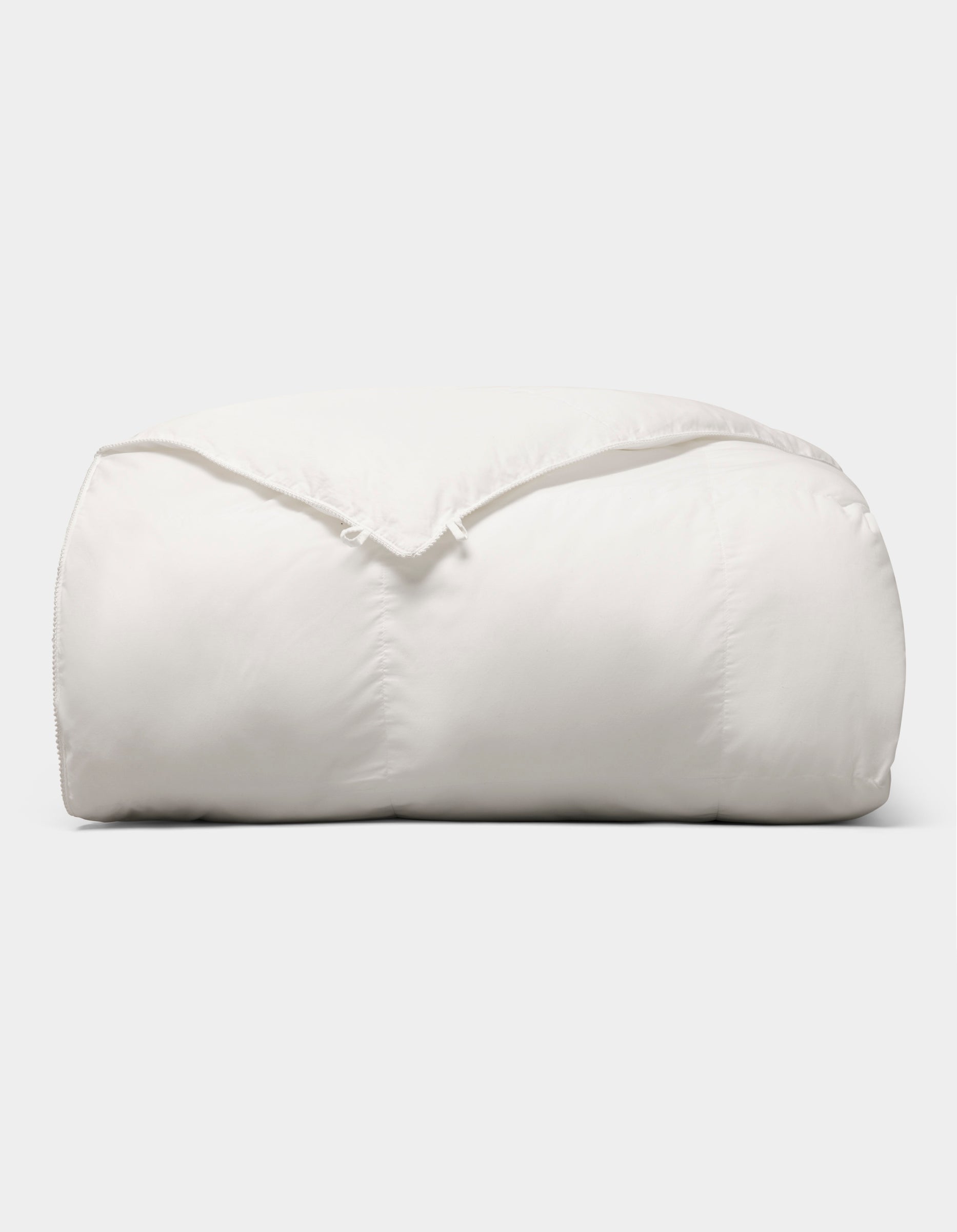 The Cozy Earth Down Alternative Comforter is neatly folded and fluffy, displayed against a plain light gray background. |Filling:Standard
