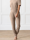 Person wearing beige Cozy Earth Rib Knit Joggers on a wooden floor with a white paneled wall background |Color:Suede