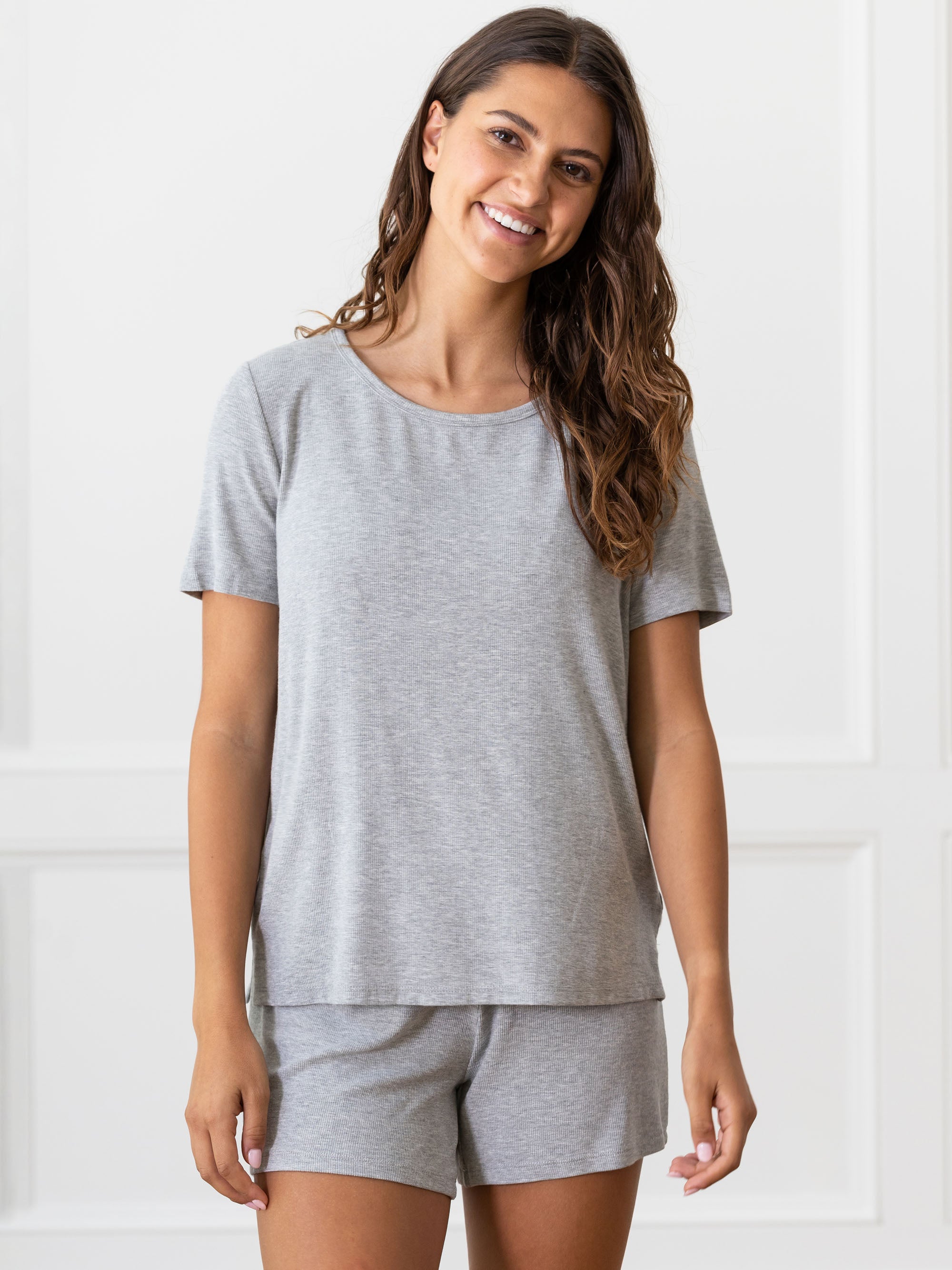 Woman wearing a grey Cozy Earth Rib Knit Short Sleeve Lounge Top and gray shorts against a white background |Color:Grey