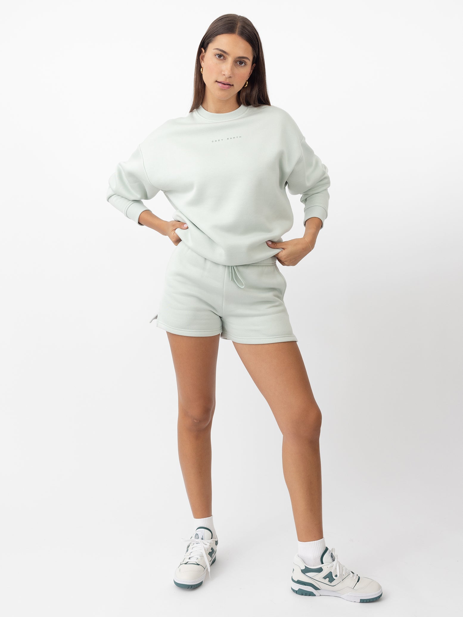 Arctic CityScape Pullover Crew. The Pullover is being worn by a female model. Accompanying city scape clothing is being worn to complete the look of the outfit. The photo was taken with a white background. 