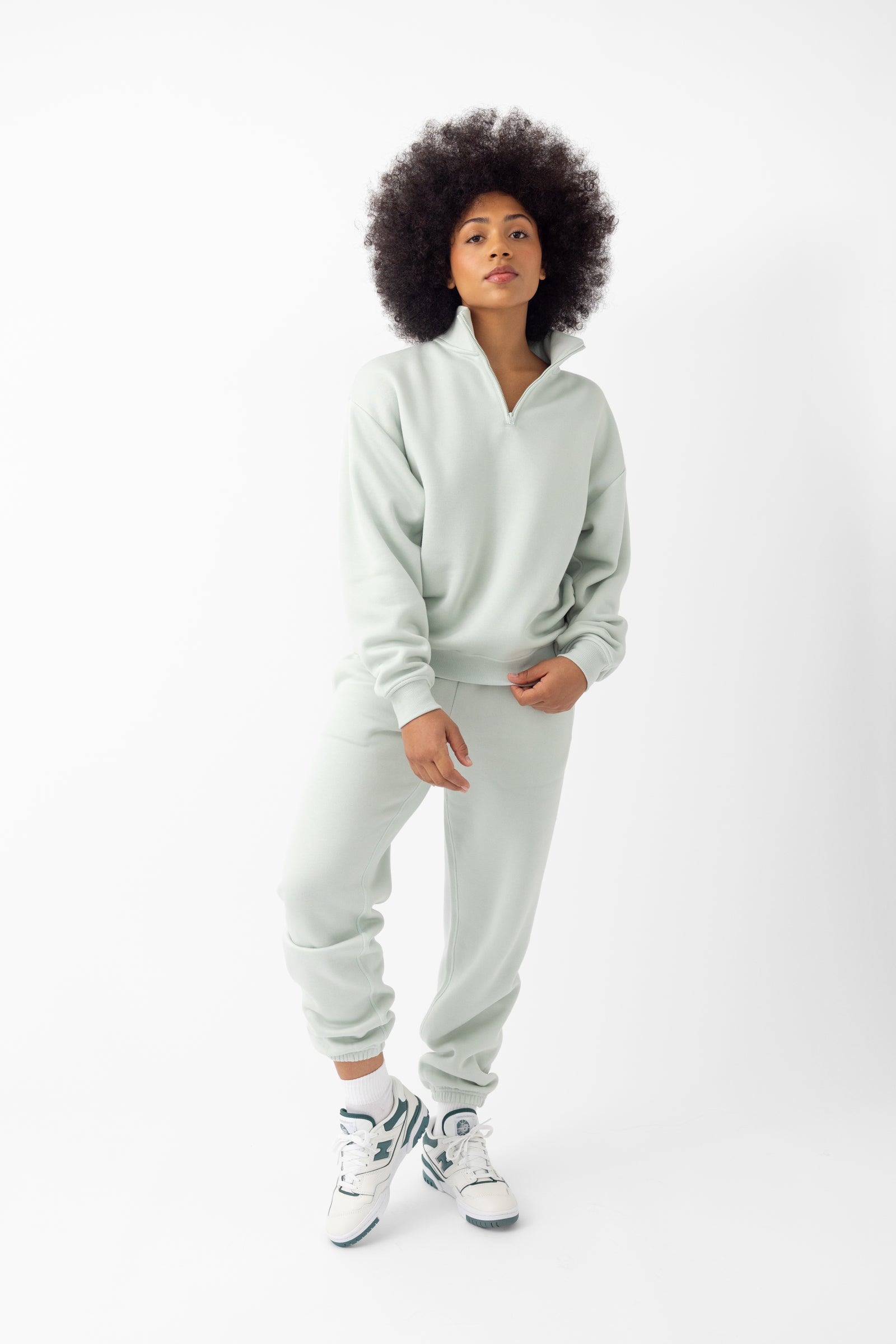 Arctic CityScape Quarter Zip. The quarter zip is being worn by a female model. The model is wearing accompanying CityScape clothing to complete the look of the quarter zip. The photo was taken with a white background.