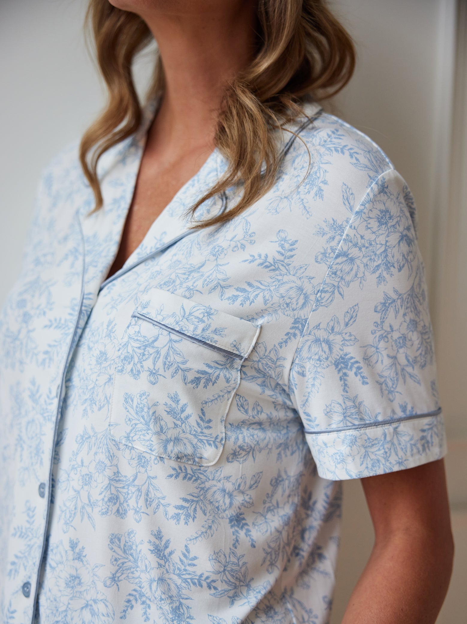 Close up of woman wearing blue toile short sleeve pajama top