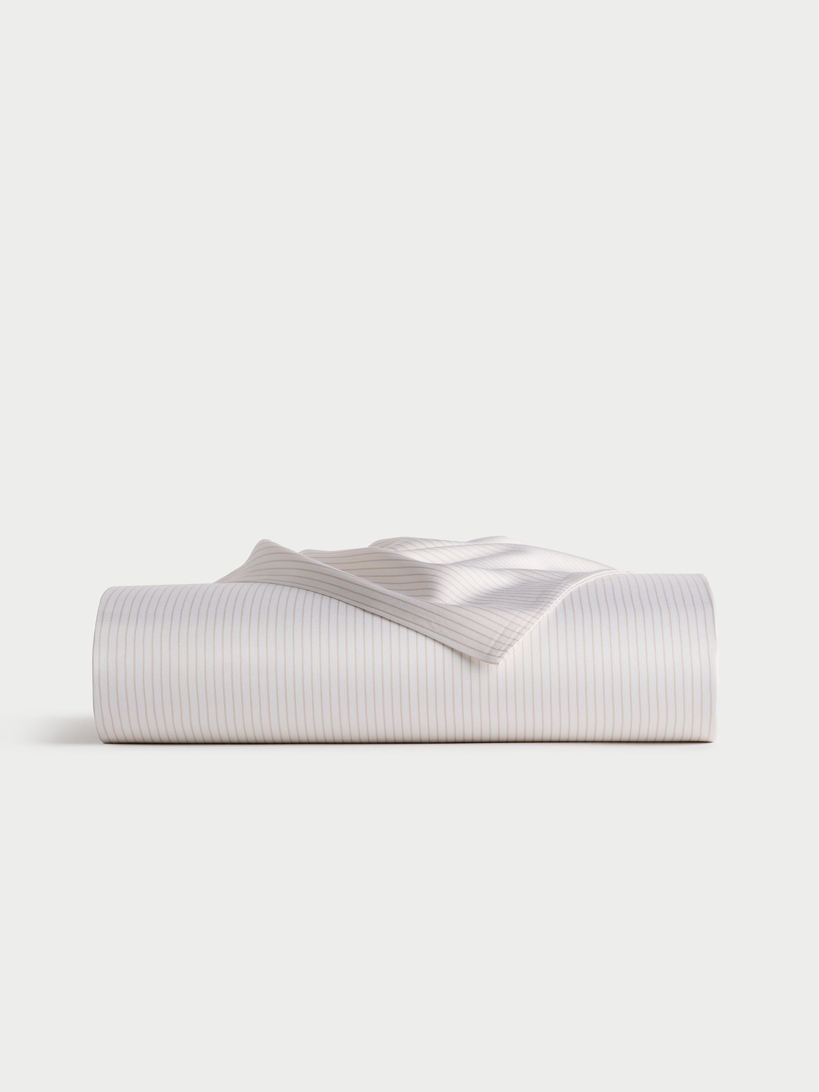 Displayed against a plain, light background is the Bamboo Flat Sheet by Cozy Earth, neatly folded and featuring subtle, thin blue stripes on a white base.