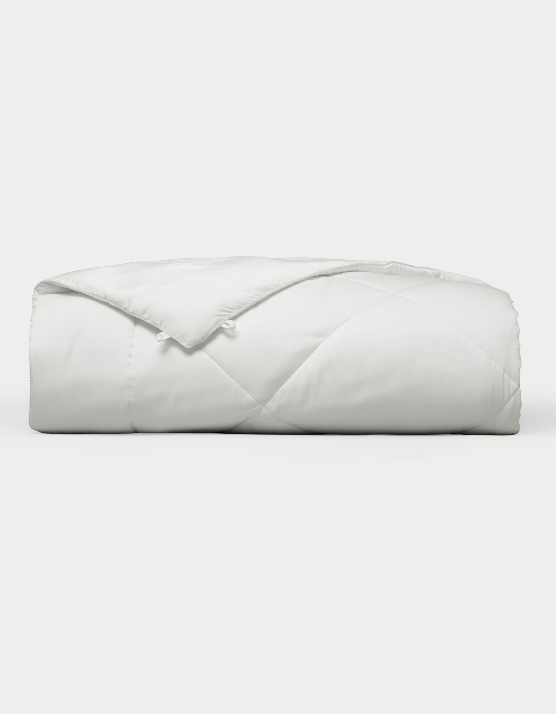 The Cozy Earth Bamboo Viscose Comforter, featuring a quilted design, is neatly folded and displayed against a plain white background. |Filling:Extra
