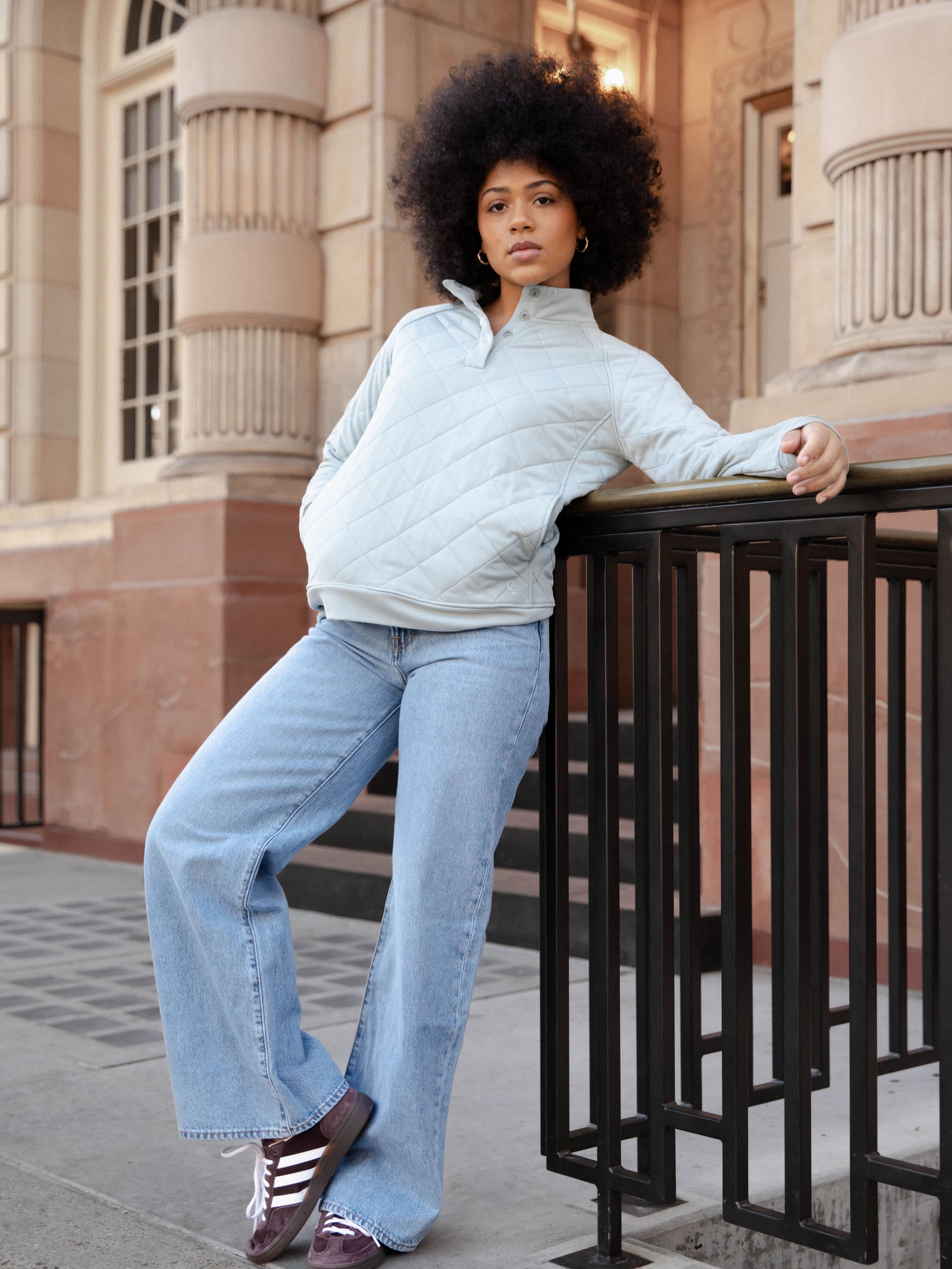 Woman wearing a white Cozy Earth Brushed Bamboo Quilted Pullover against a city background