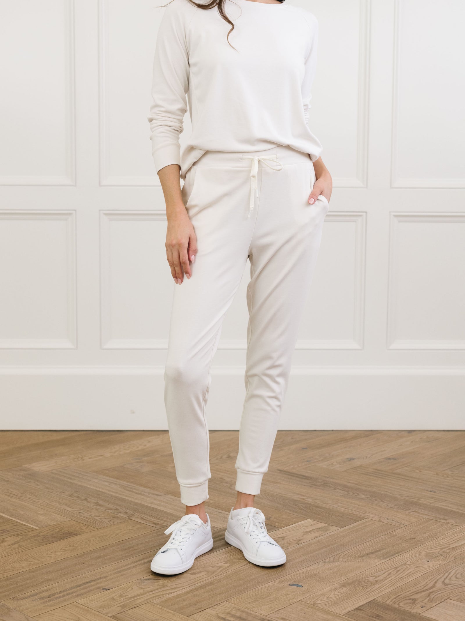 Ivory Bamboo Jogger Set modeled by a woman. The photo was taken in a high contrast setting, showing off the colors and lines of the pajamas.