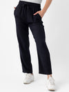 Person wearing Cozy Earth's Women's Sunset Cropped Pant in Jet Black with hands in pockets and white sneakers. The background is plain white. |Color:Jet Black