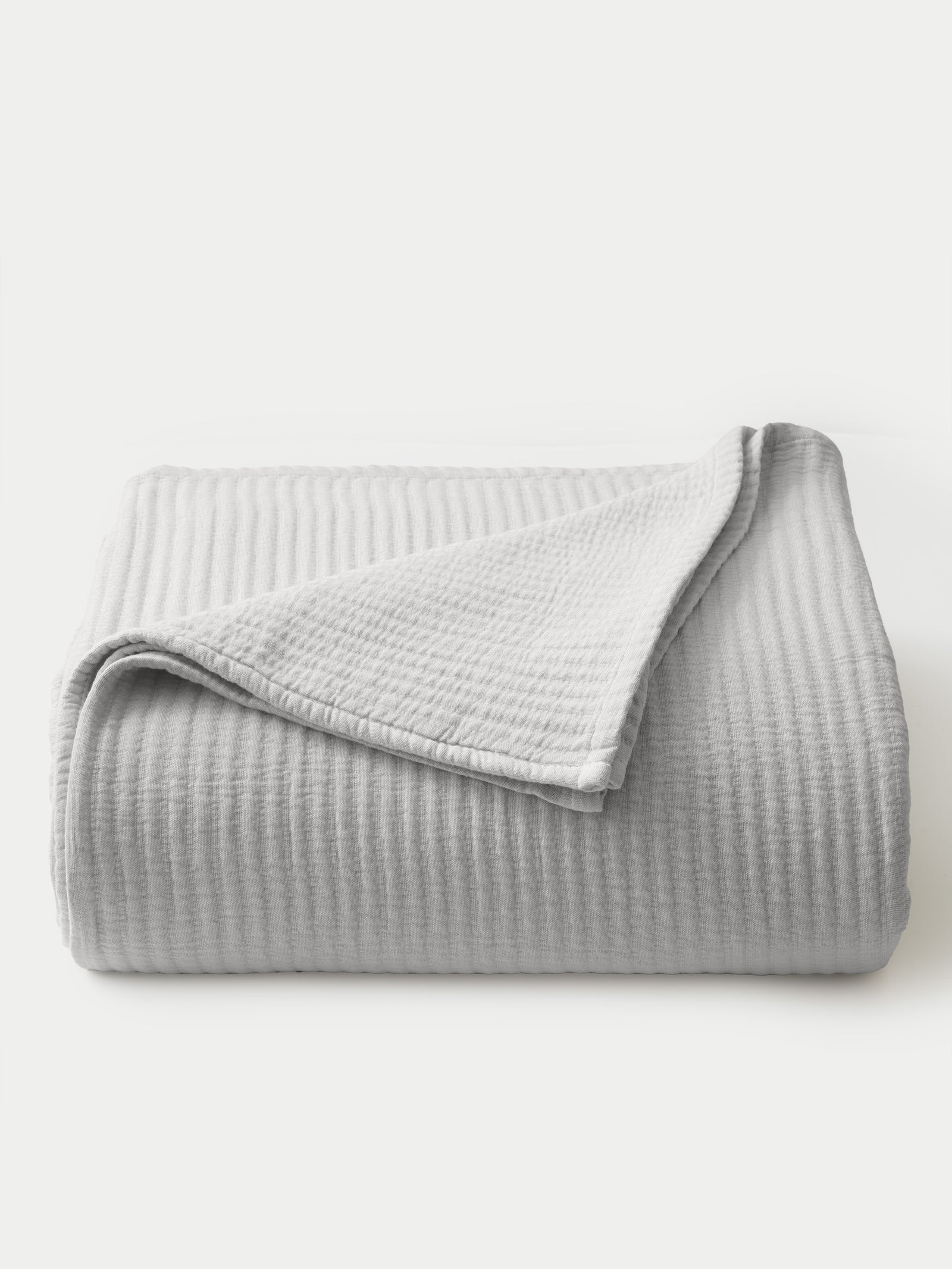 Light Grey coverlet folded with white background 
