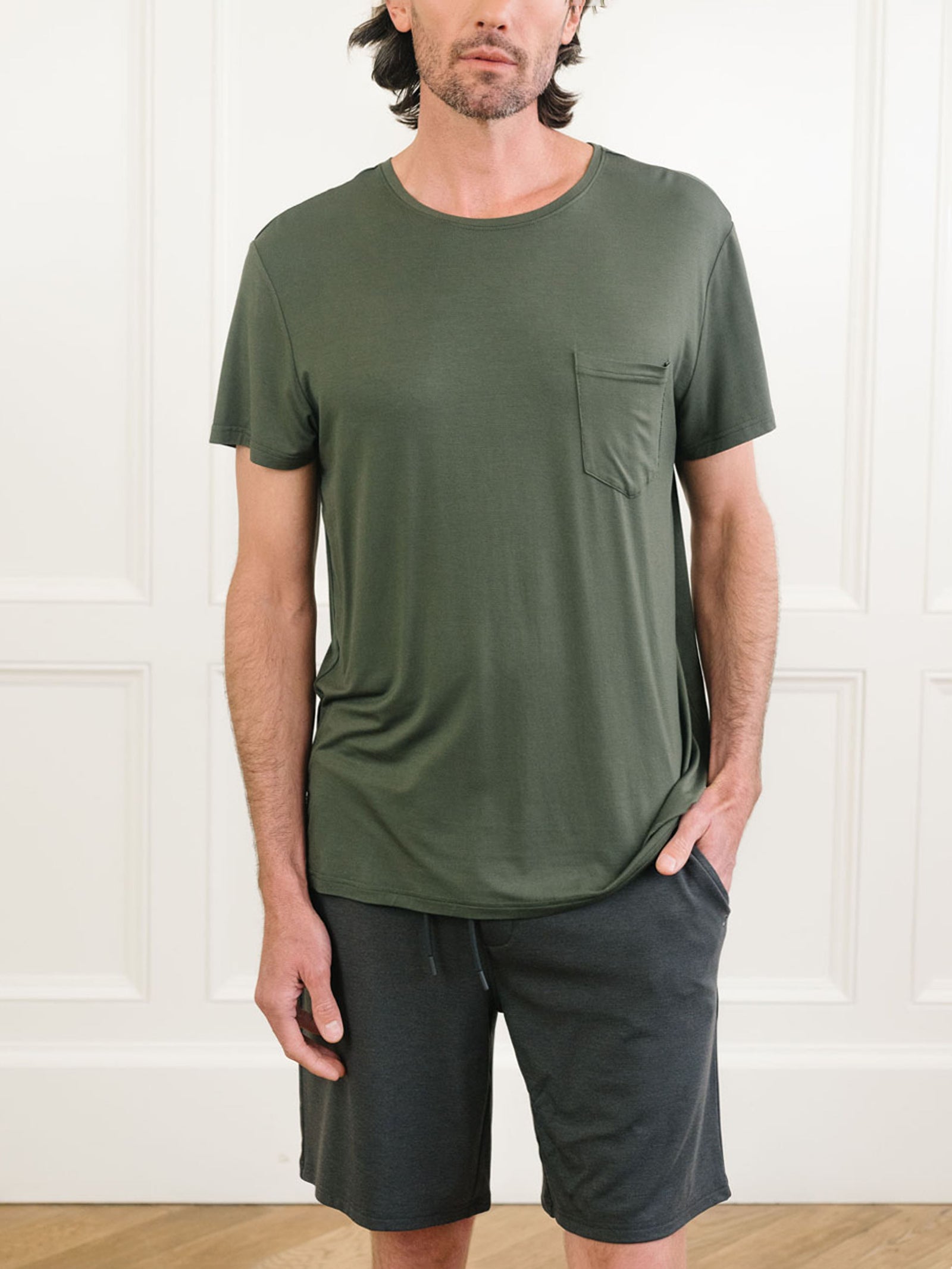 Olive Men's Stretch-Knit Bamboo Lounge Tee. A man is wearing the lounge tee in a well lit home.