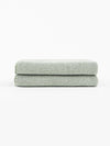 A pair of Nantucket Hand Towels in Heathered Clay is stacked in front of a white background. |Color:Heathered Sage