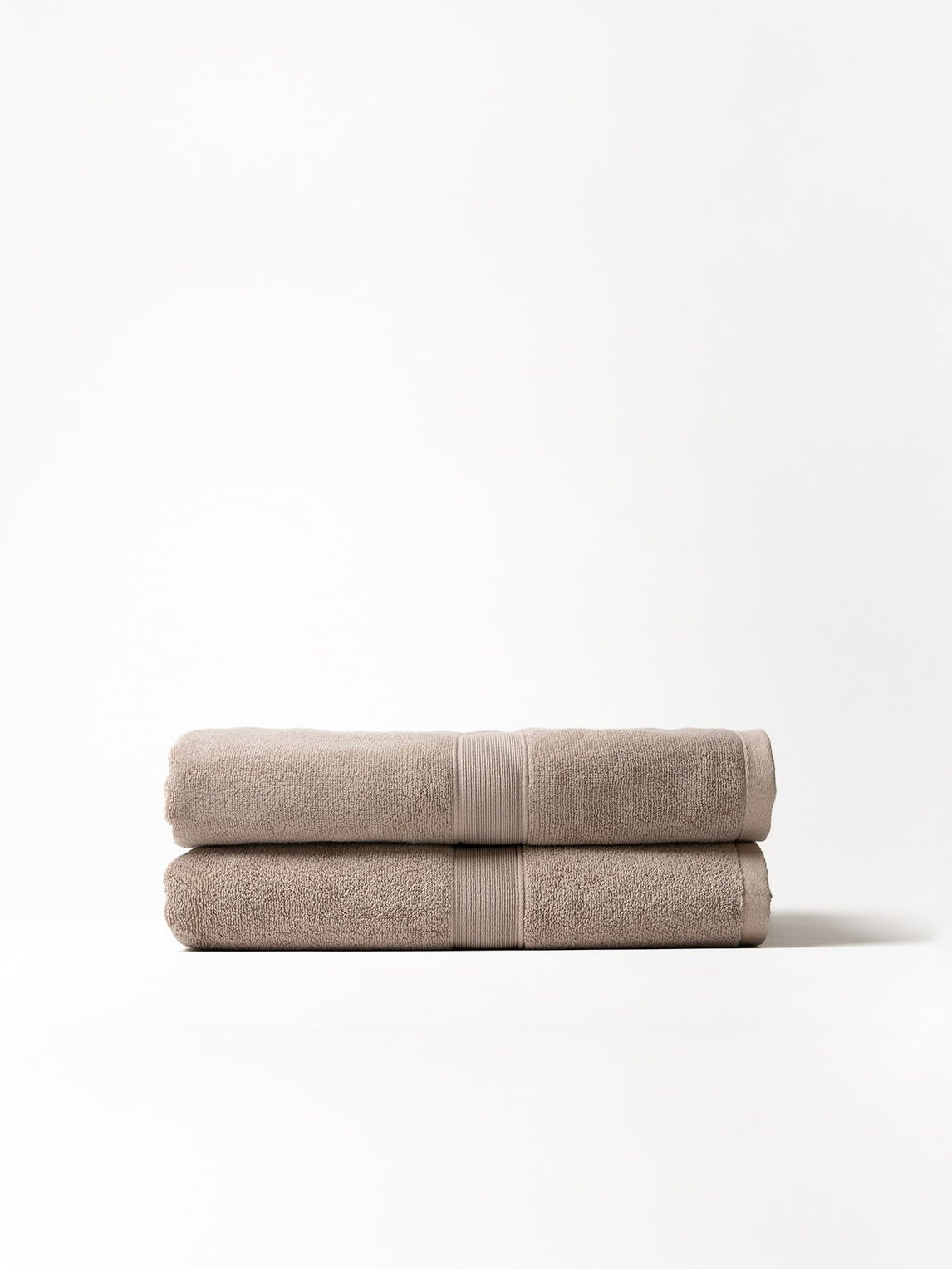 Two luxe bath sheets folded with white background 
