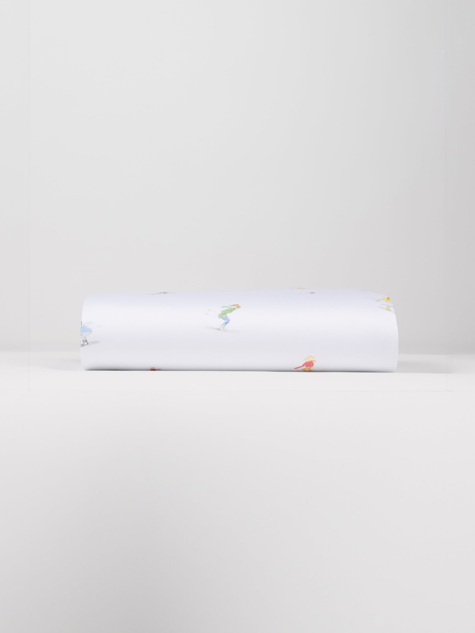 A neatly folded Bamboo Duvet Cover by Cozy Earth, showcasing small, colorful illustrations of people engaged in various activities against a plain white background.