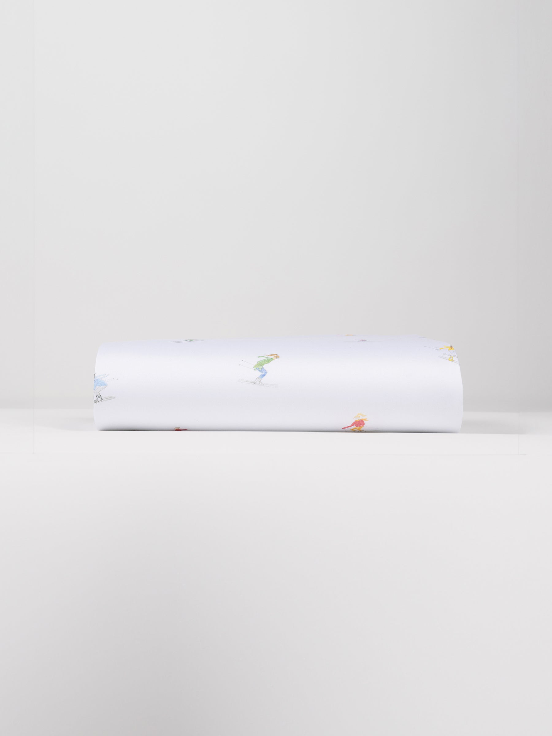 A neatly folded Bamboo Duvet Cover by Cozy Earth, showcasing small, colorful illustrations of people engaged in various activities against a plain white background. |Color:Skiers