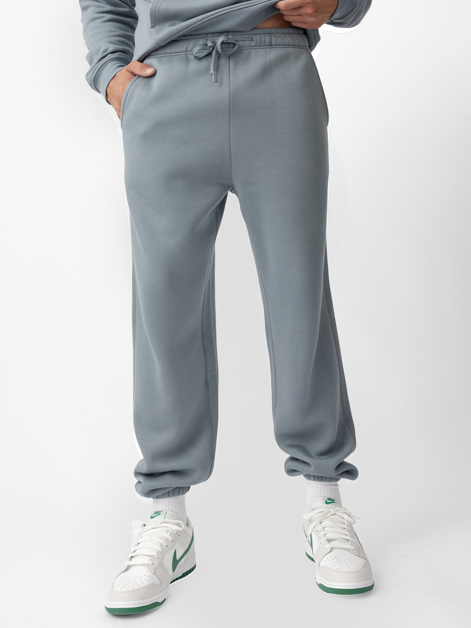 Man wearing smokey blue cityscape sweats with white background\