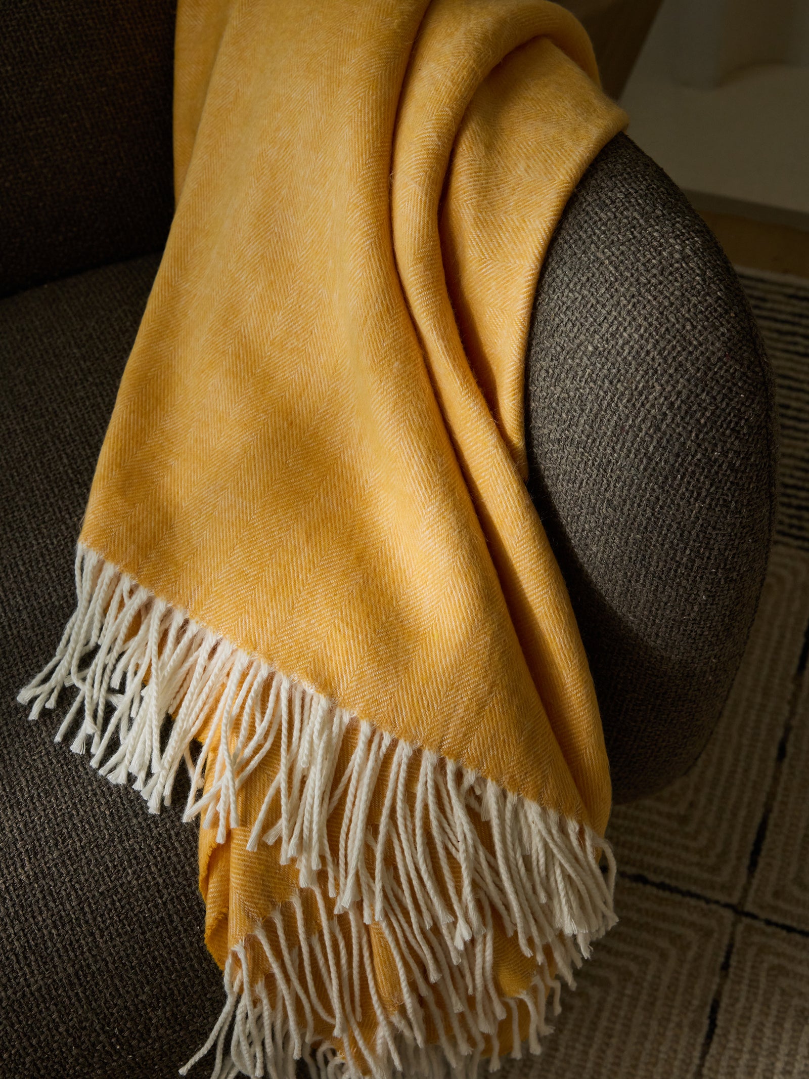 Sunflower herringbone tassel throw draped over recliner