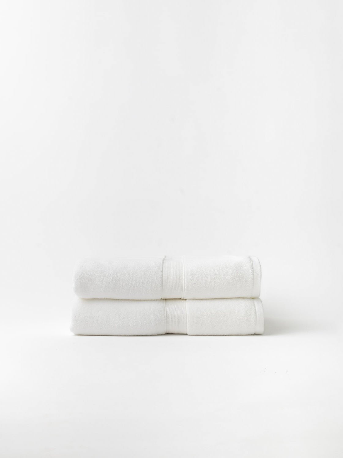 Two luxe bath sheets folded with white background 