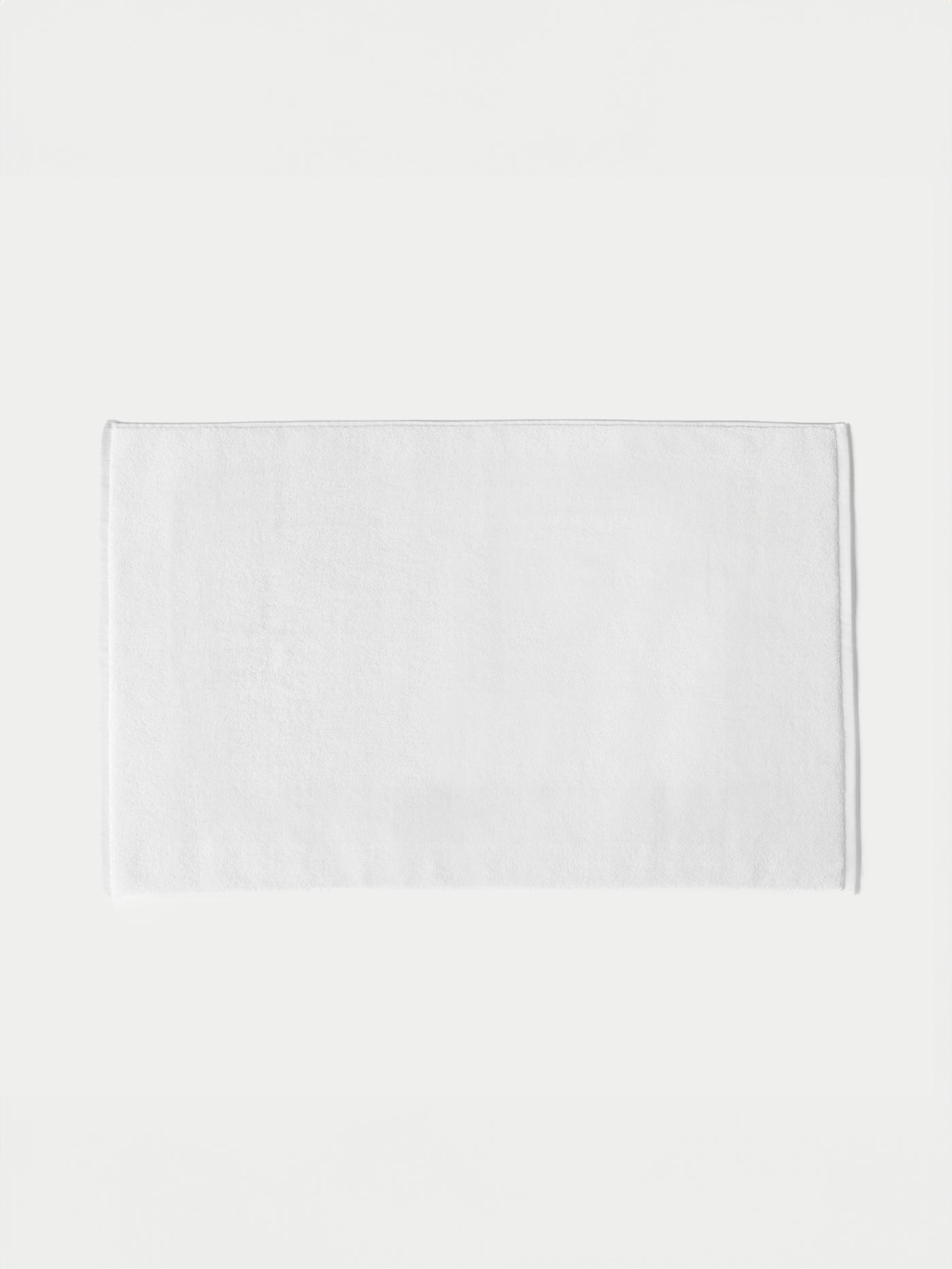The Cozy Earth Loop Terry Bath Mat, featuring a plain white rectangular design, is displayed on a white background.
