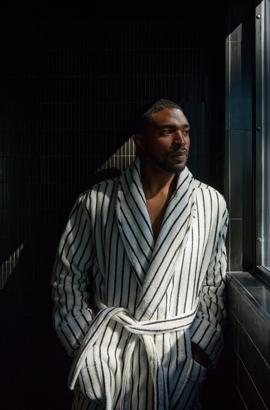 Man wearing a striped robe in a bathroom setting
