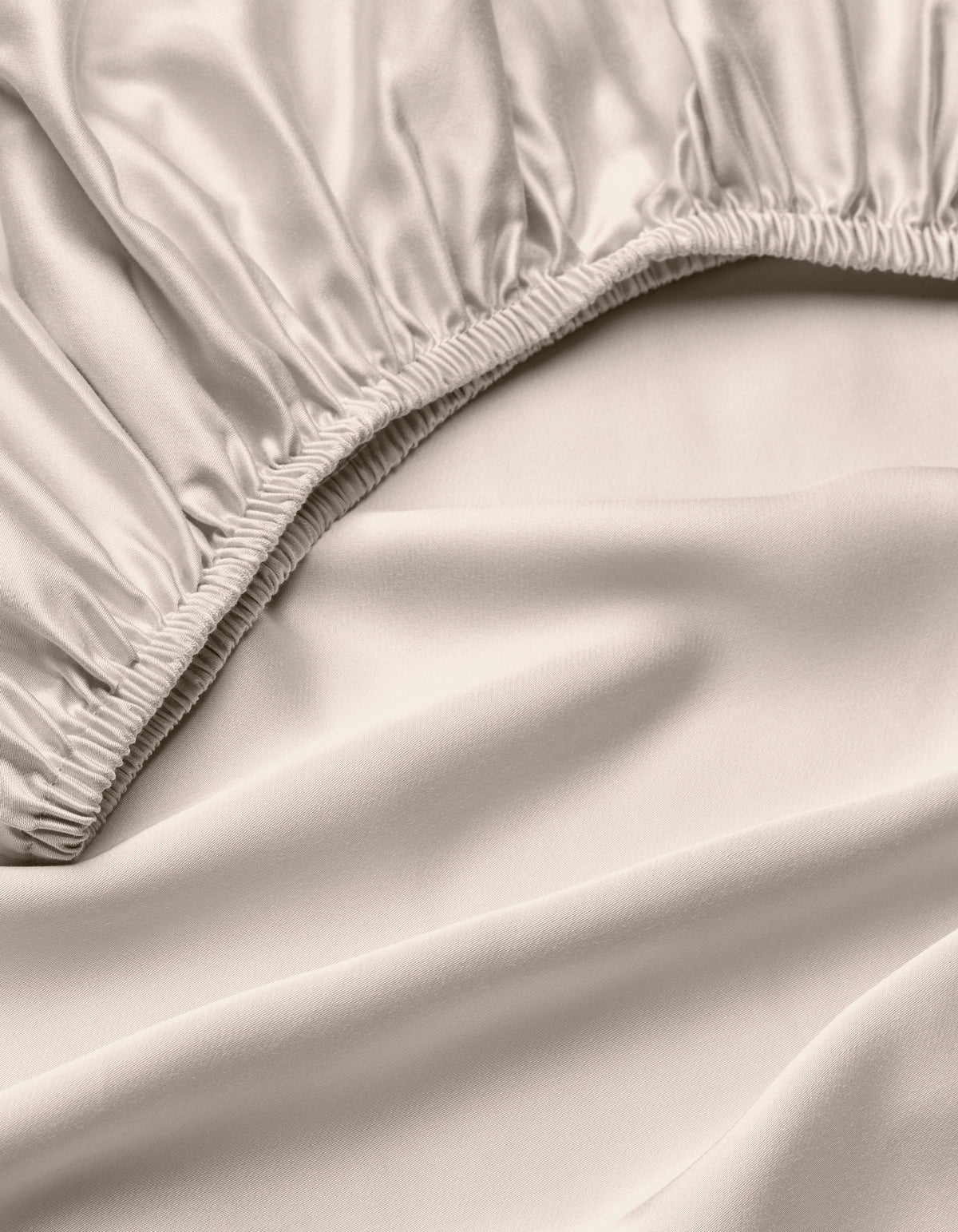 A close-up of the Cozy Earth Bamboo Fitted Sheet in light beige, highlighting its silky, smooth fabric, gathered elastic edges, and soft folds.|Color:Driftwood