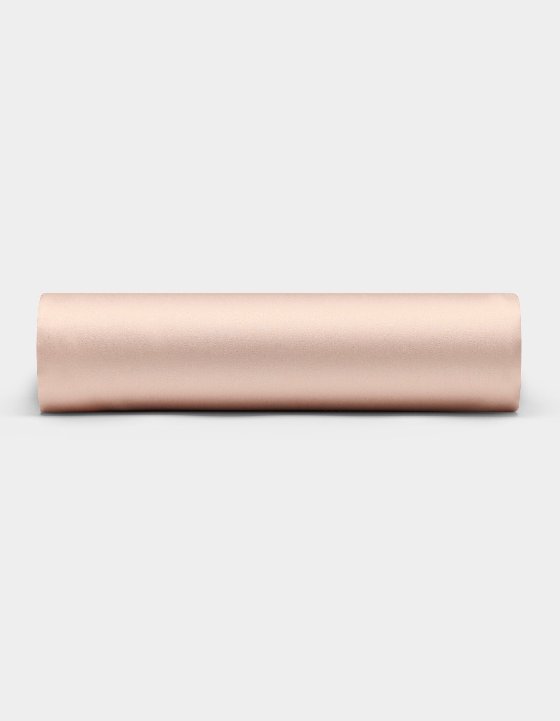 A Cozy Earth Bamboo Fitted Sheet in a light beige shade is shown rolled up on a plain white background, viewed from the side.|Color:Peony