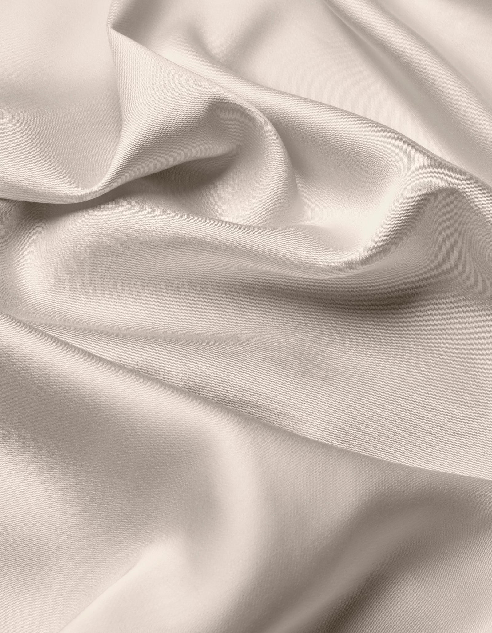 The Cozy Earth Bamboo Flat Sheet features a smooth, light-colored fabric with soft folds and gentle draping, creating a silky, elegant texture.