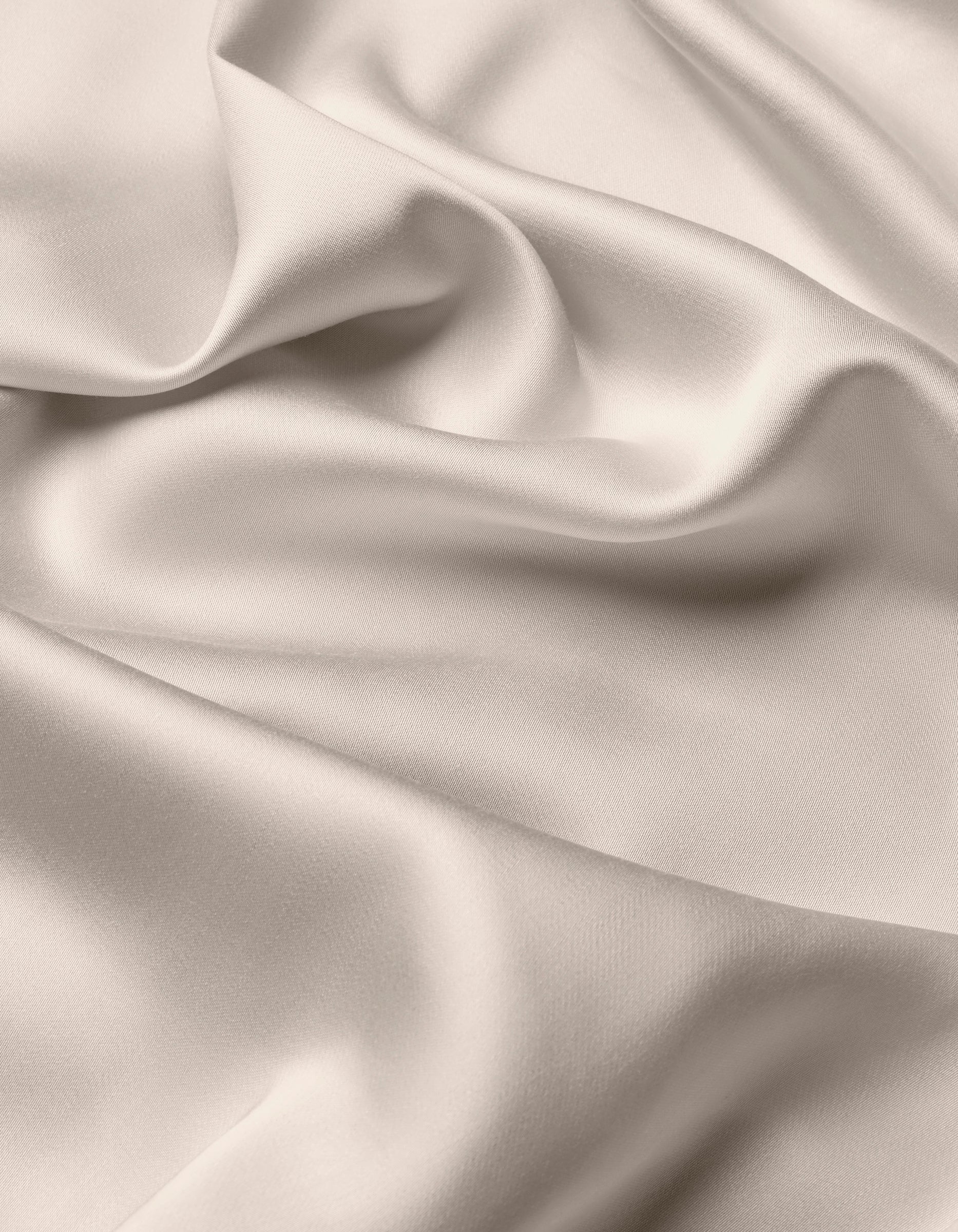 The Cozy Earth Bamboo Sheet Set features smooth, light-colored satin fabric with gentle folds and soft shadows for a flowing, elegant texture.|Color:Driftwood