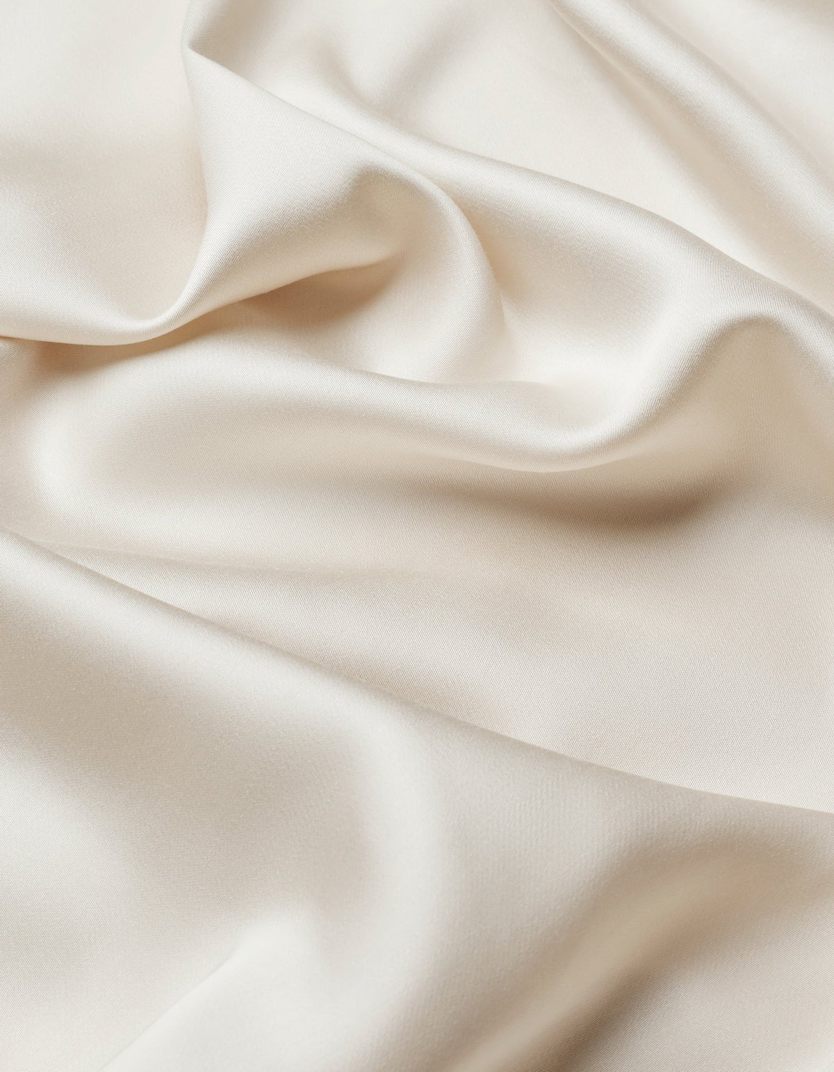Close-up of Cozy Earth Bamboo Sheet Set in smooth, ivory satin with soft folds and gentle waves, showcasing its silky texture and subtle sheen.|Color:Oat