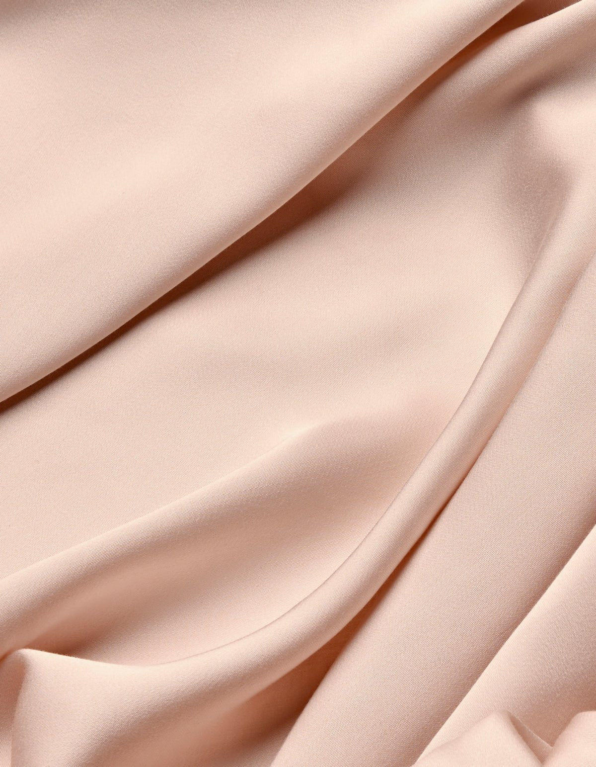 The Cozy Earth Bamboo Sheet Set features soft, light pink fabric with a smooth texture, gently draped to create subtle folds and shadows.|Color:Peony