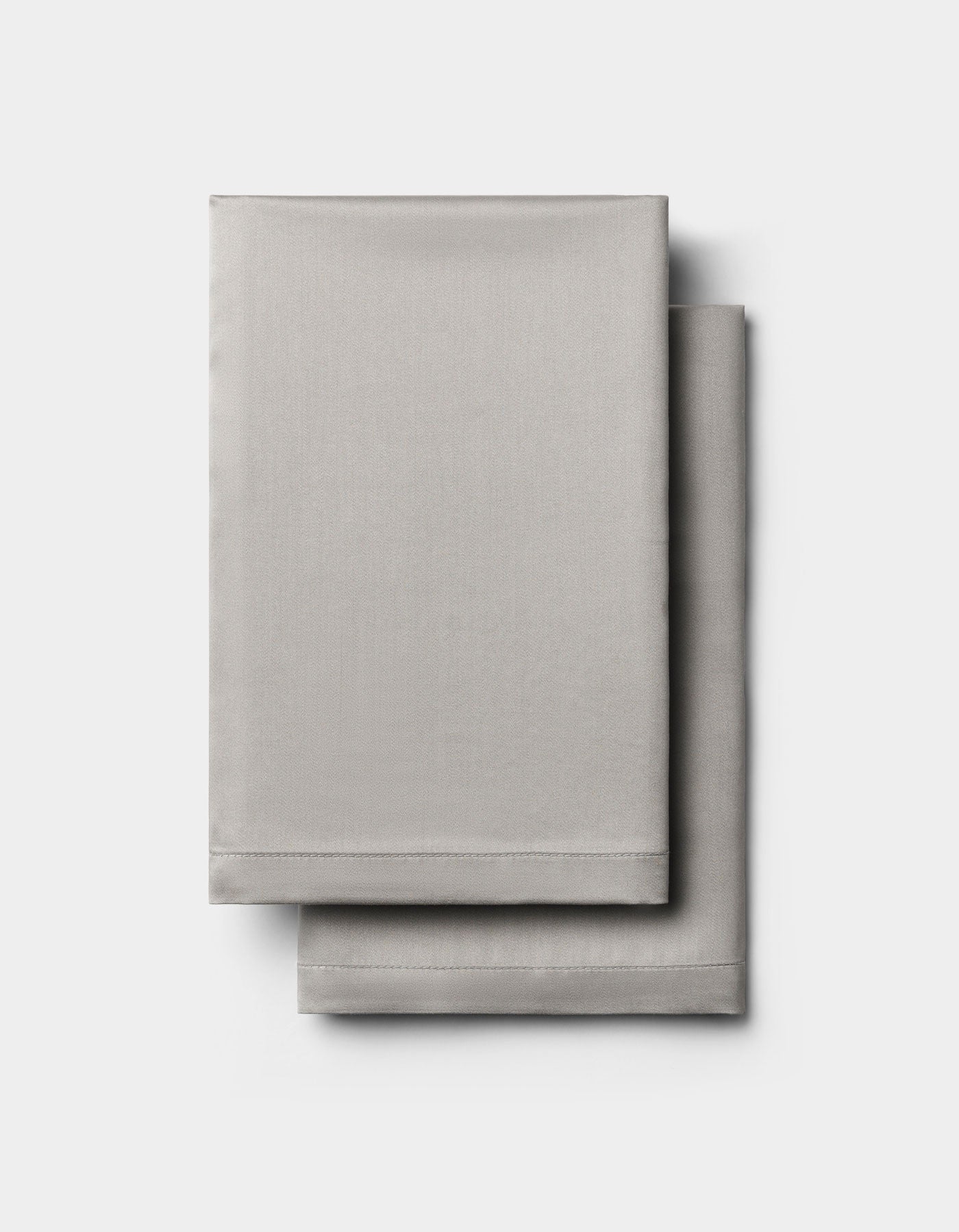 Two neatly folded light gray Cozy Earth Bamboo Pillowcases stacked on a plain white background.