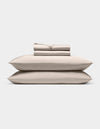 A neatly stacked Cozy Earth Bamboo Sheet Set, featuring two pillows, a folded fitted sheet, flat sheet, and pillowcases, displayed against a plain white background.|Color:Driftwood