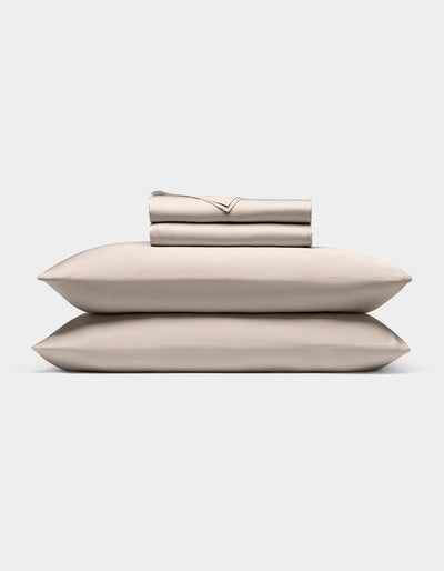 A neatly stacked Cozy Earth Bamboo Sheet Set, featuring two pillows, a folded fitted sheet, flat sheet, and pillowcases, displayed against a plain white background.|Color:Driftwood