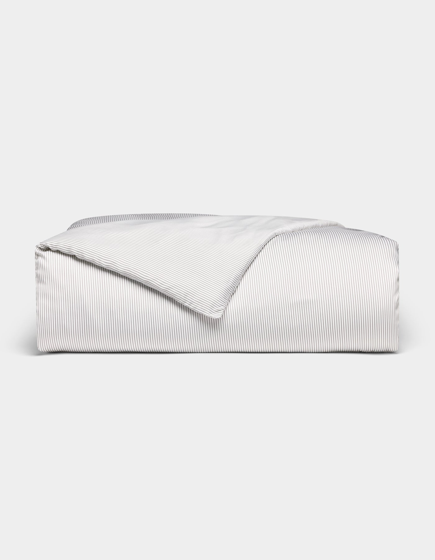 The Bamboo Duvet Cover by Cozy Earth, shown neatly folded with a corner flipped over, features white and gray pinstripes and is displayed against a plain white background.