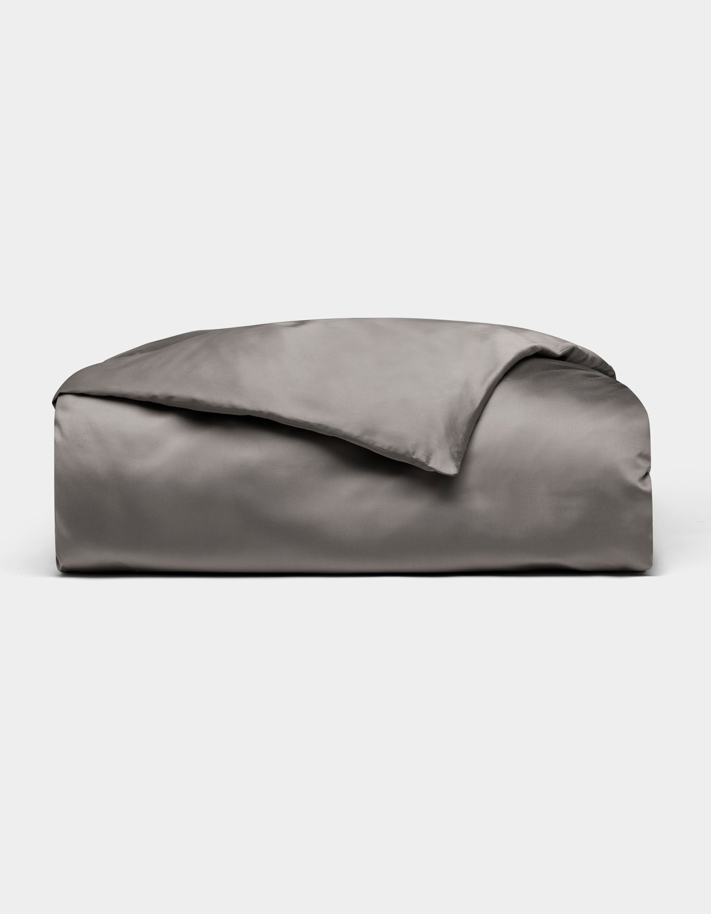 A neatly folded, shiny gray Bamboo Duvet Cover by Cozy Earth is displayed on a plain white background.|Color:Charcoal