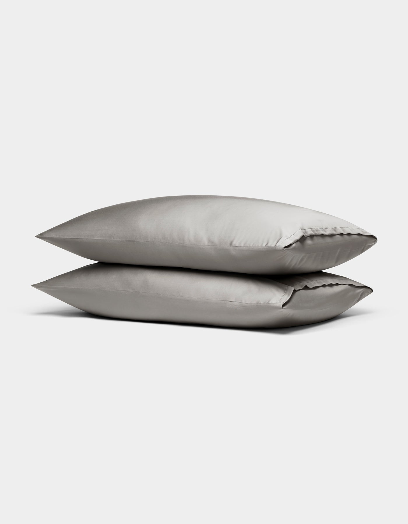 Two Cozy Earth Bamboo Pillowcases in light gray are stacked neatly on top of each other against a plain white background.|Color:Light Grey