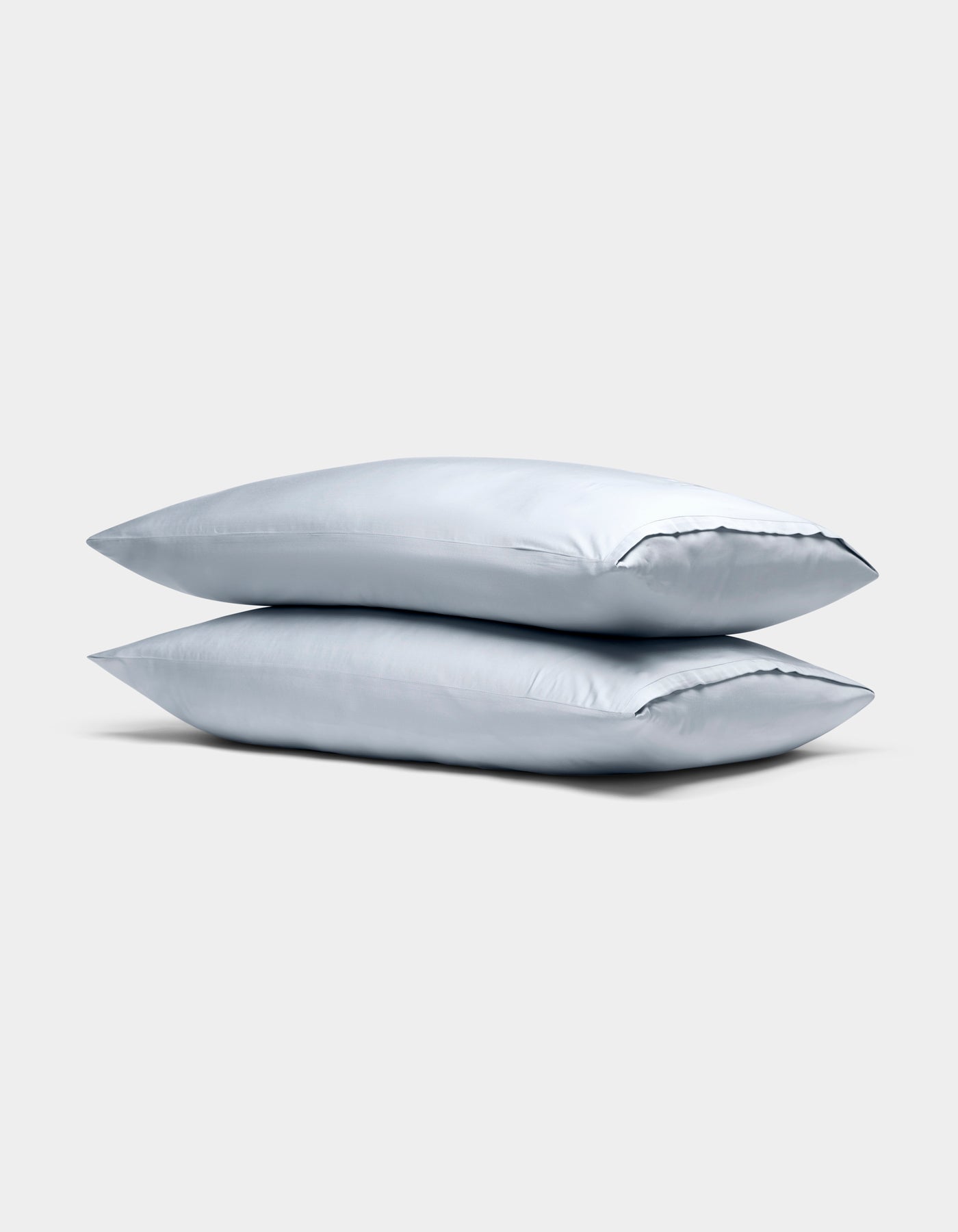 Two Cozy Earth Bamboo Pillowcases in light gray are stacked neatly against a plain, light gray background.|Color:Shore