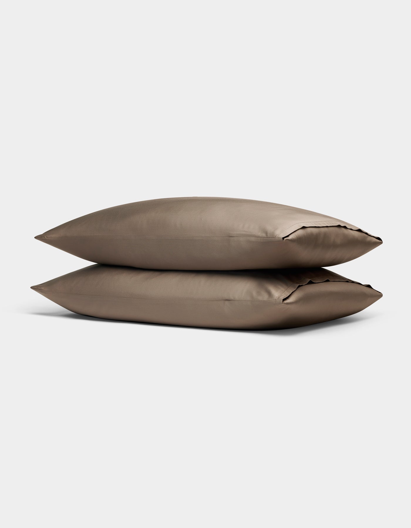 Two Cozy Earth Bamboo Pillowcases in taupe, rectangular and neatly stacked on top of each other, are displayed against a plain light gray background.