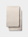 Two neatly folded Cozy Earth Silk Pillowcases in beige, stacked together against a plain white background.|Color:Driftwood