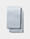 Two neatly folded Cozy Earth Silk Pillowcases are stacked on a plain, light gray background. |Color:Shore