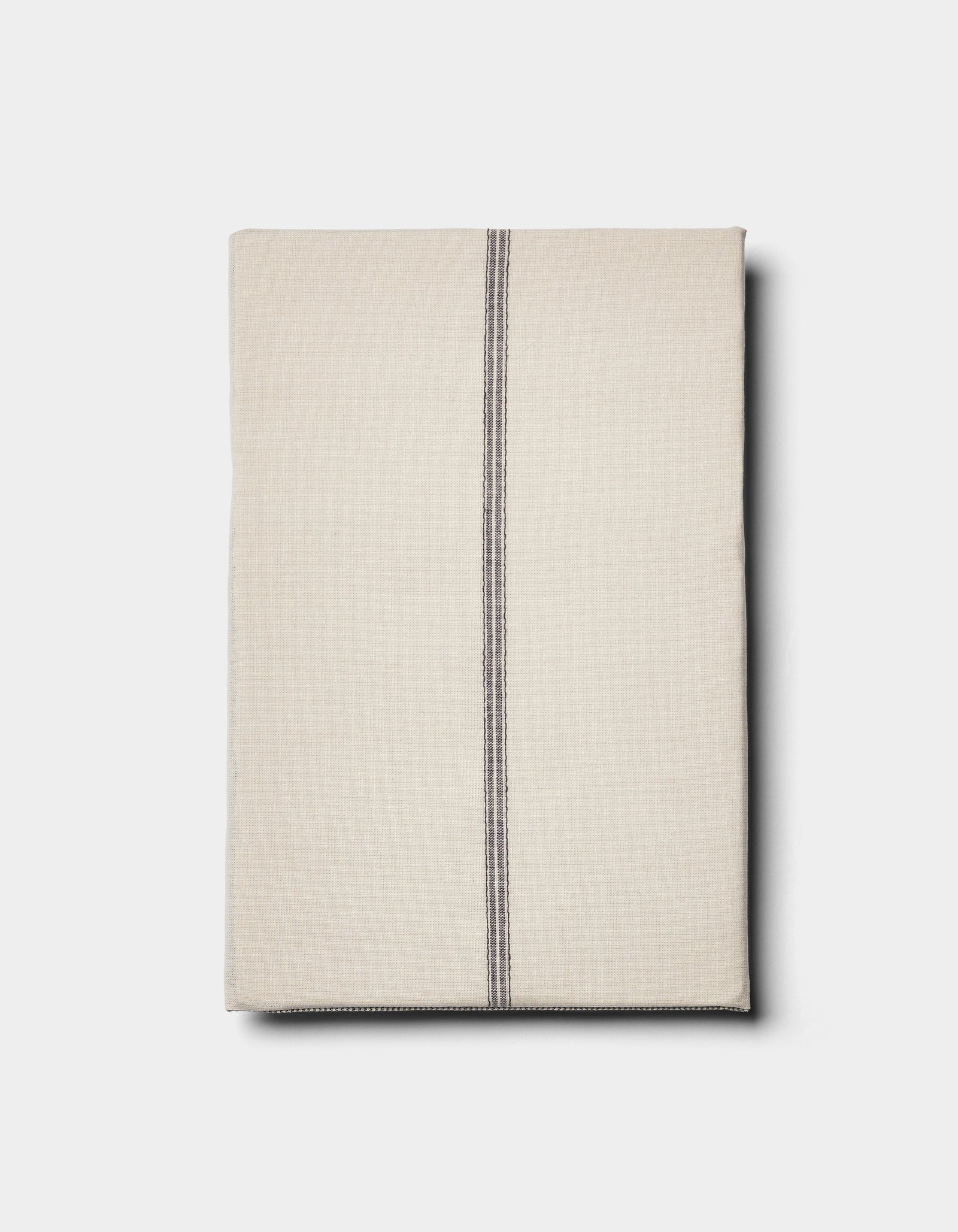 The Cozy Earth Baja Double Sided Sham is shown neatly folded in beige, featuring a single off-center vertical black stripe, set against a plain light background.