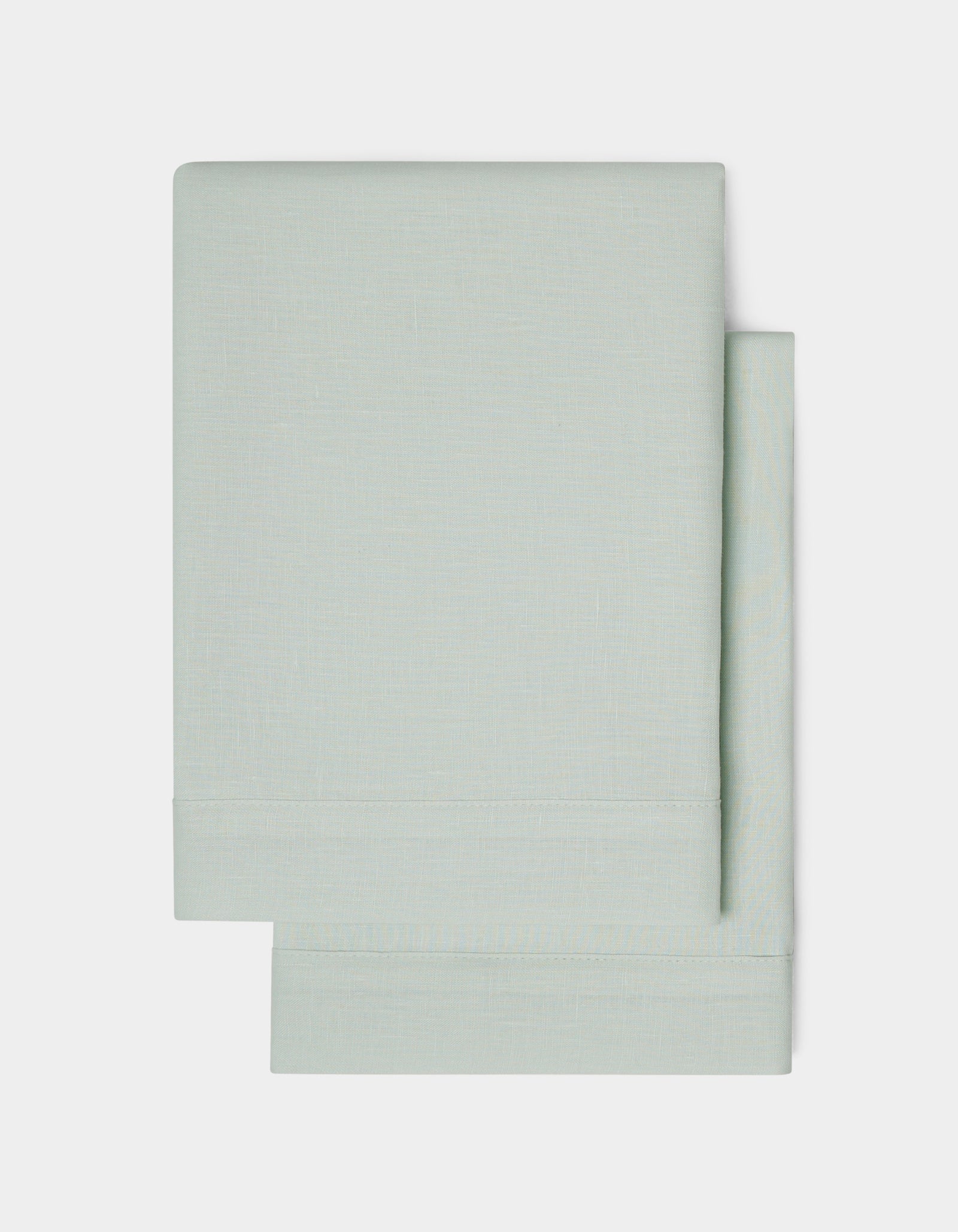 Two neatly folded Linen Shams by Cozy Earth in light gray are stacked on a plain white background, highlighting their simple and clean design.