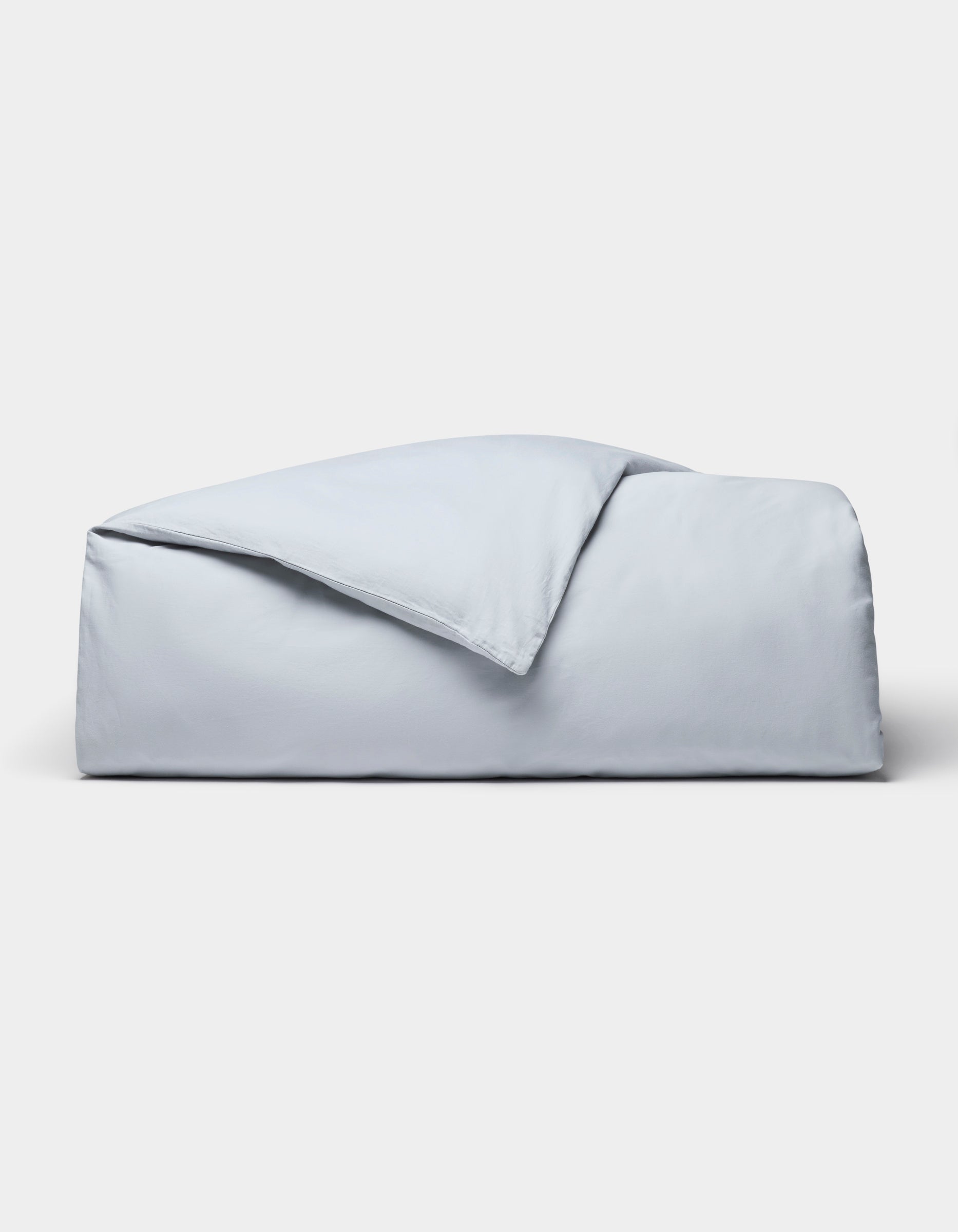 The Cozy Earth Soft-Wash Cotton Duvet Cover set, in light blue, is neatly folded and displayed against a plain white background.|Color:Shore