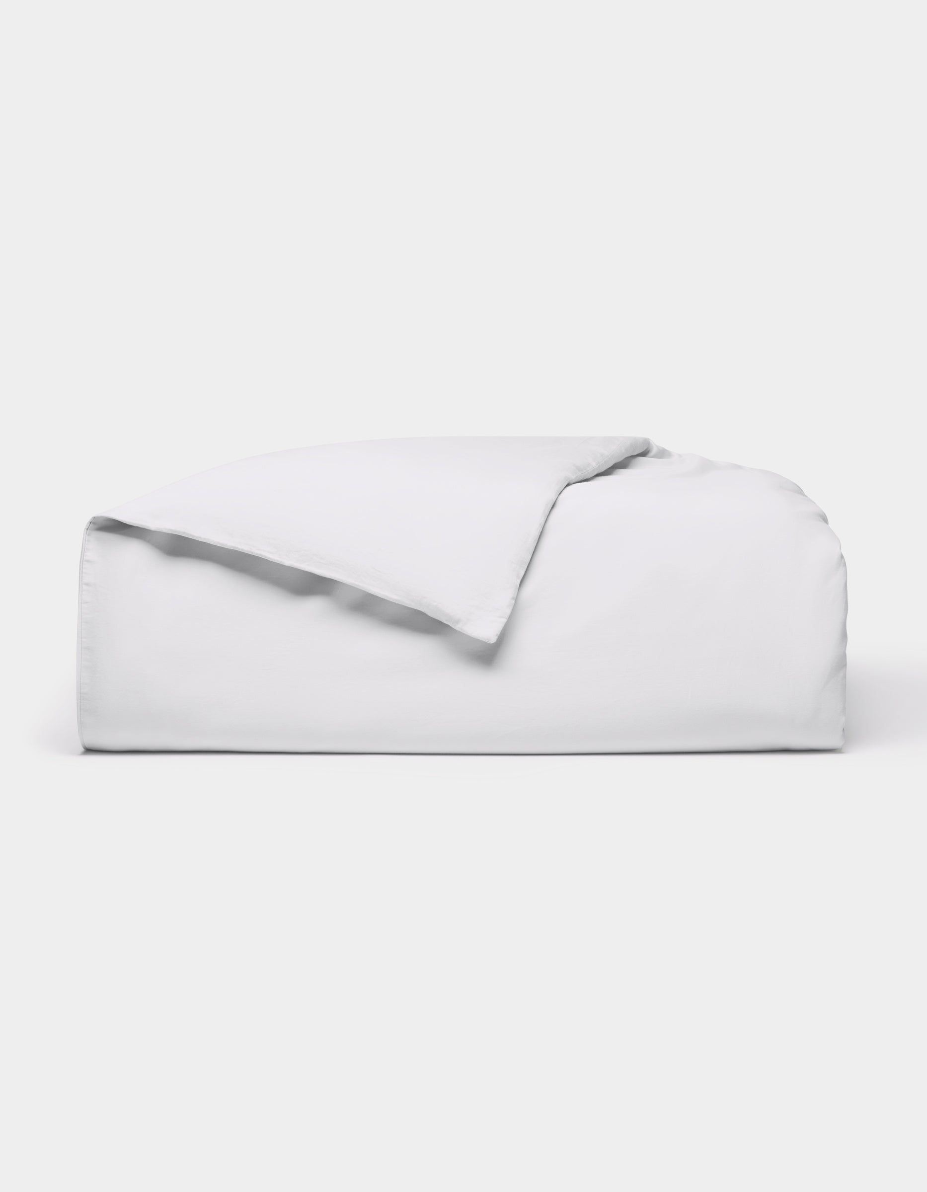 The Cozy Earth Soft-Wash Cotton Duvet Cover, in white, is neatly folded on a white background with one corner flipped over to show the inside.|Color:White