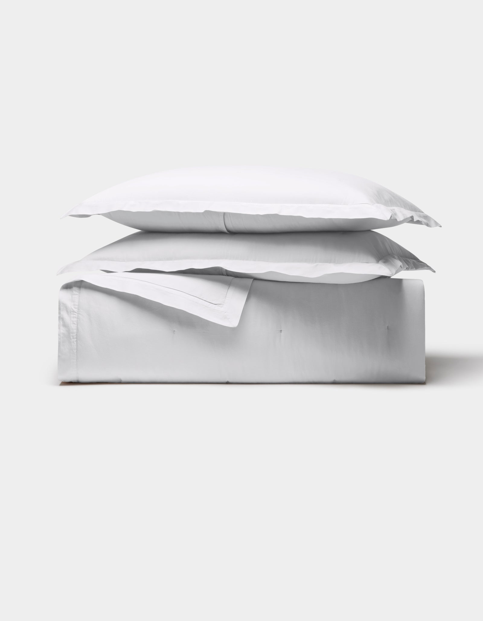 The Cozy Earth Soft-Wash Cotton Quilt Bundle is neatly folded with a pillow on top, showcased against a plain light gray background.