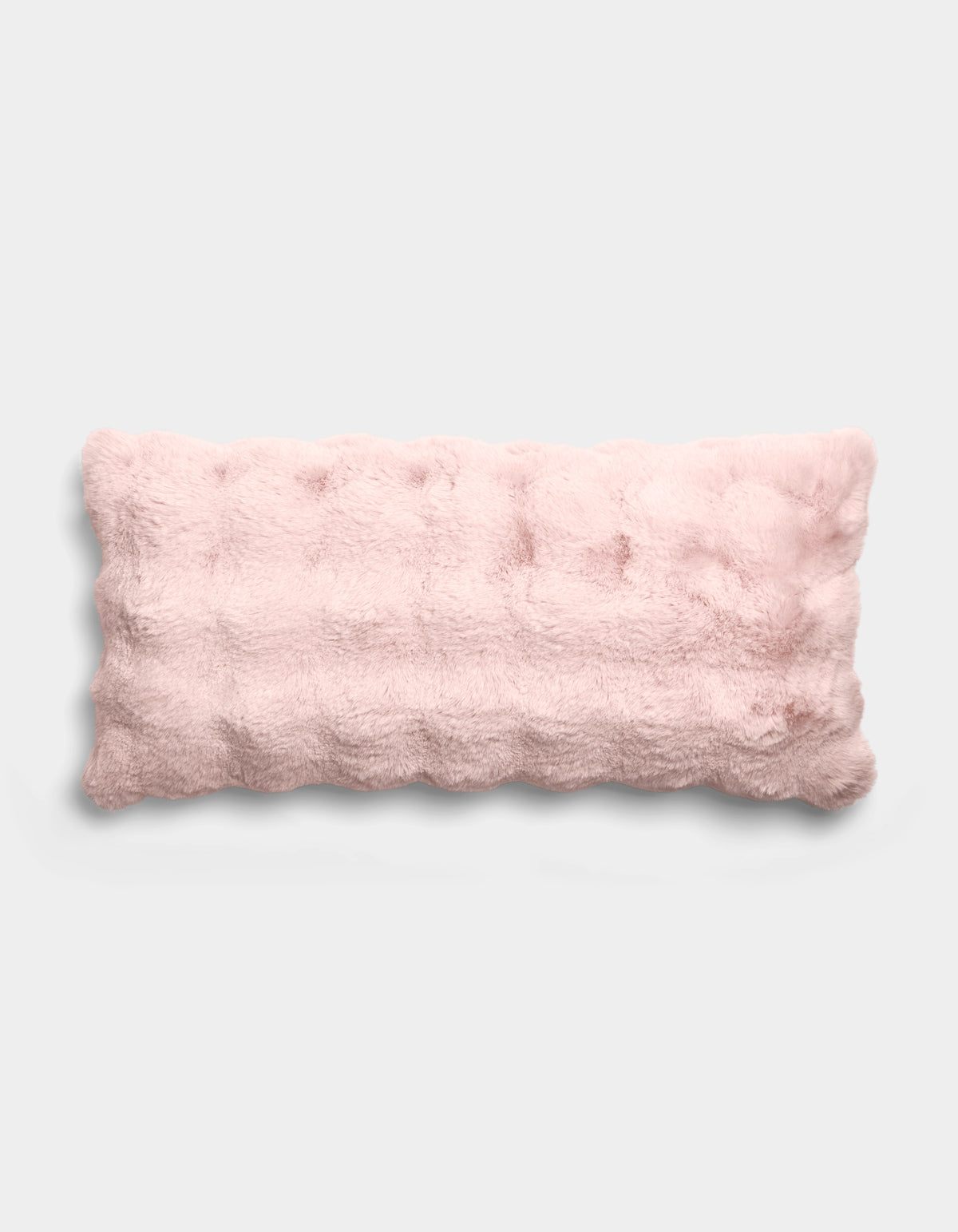 The Bubble Cuddle Pillow by Cozy Earth is a rectangular, light pink plush pillow with a tufted, fuzzy texture, displayed against a plain light gray background.|Color:Blossom |Size:14" x 30"