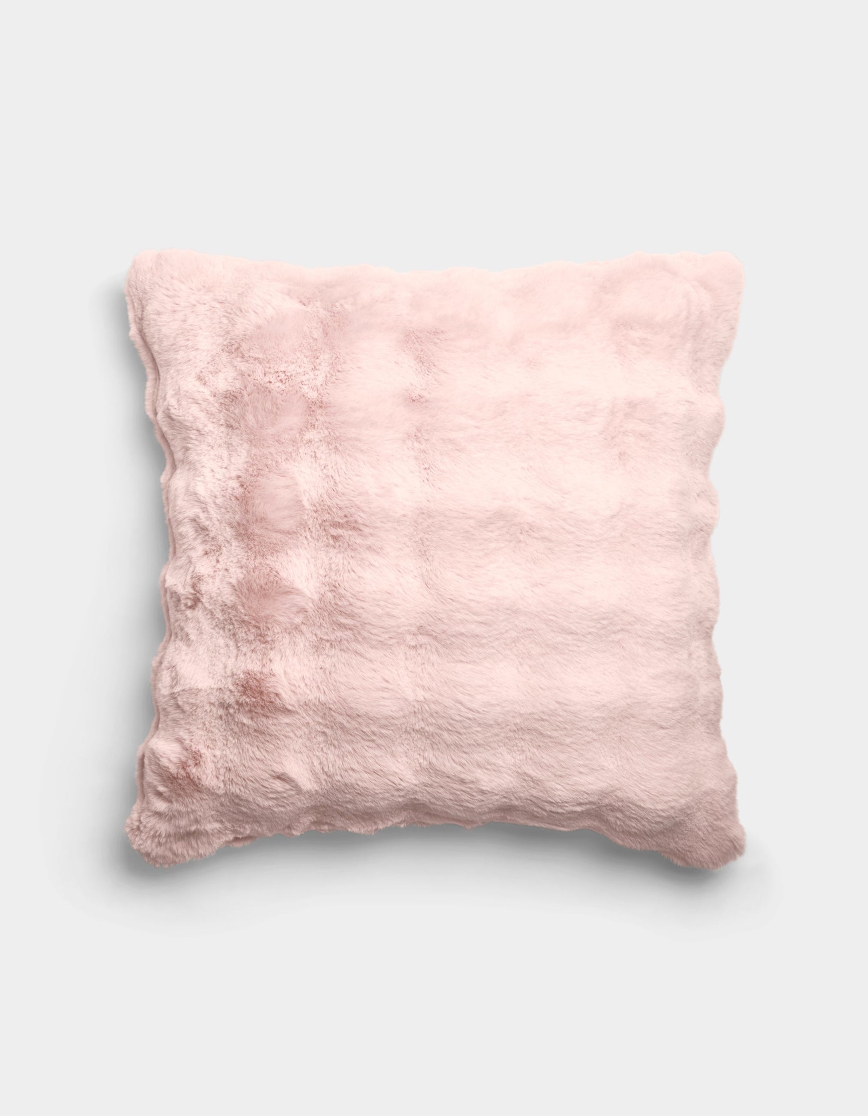 The Bubble Cuddle Pillow by Cozy Earth is a square, pale pink plush pillow with a soft, furry texture and subtle horizontal ridges, shown against a plain light gray background.|Color:Blossom |Size:24" x 24"