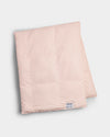 The Cozy Earth Down Alternative Throw, shown folded in light pink with a small white label near the edge, is displayed on a plain white background.|Color:Petal