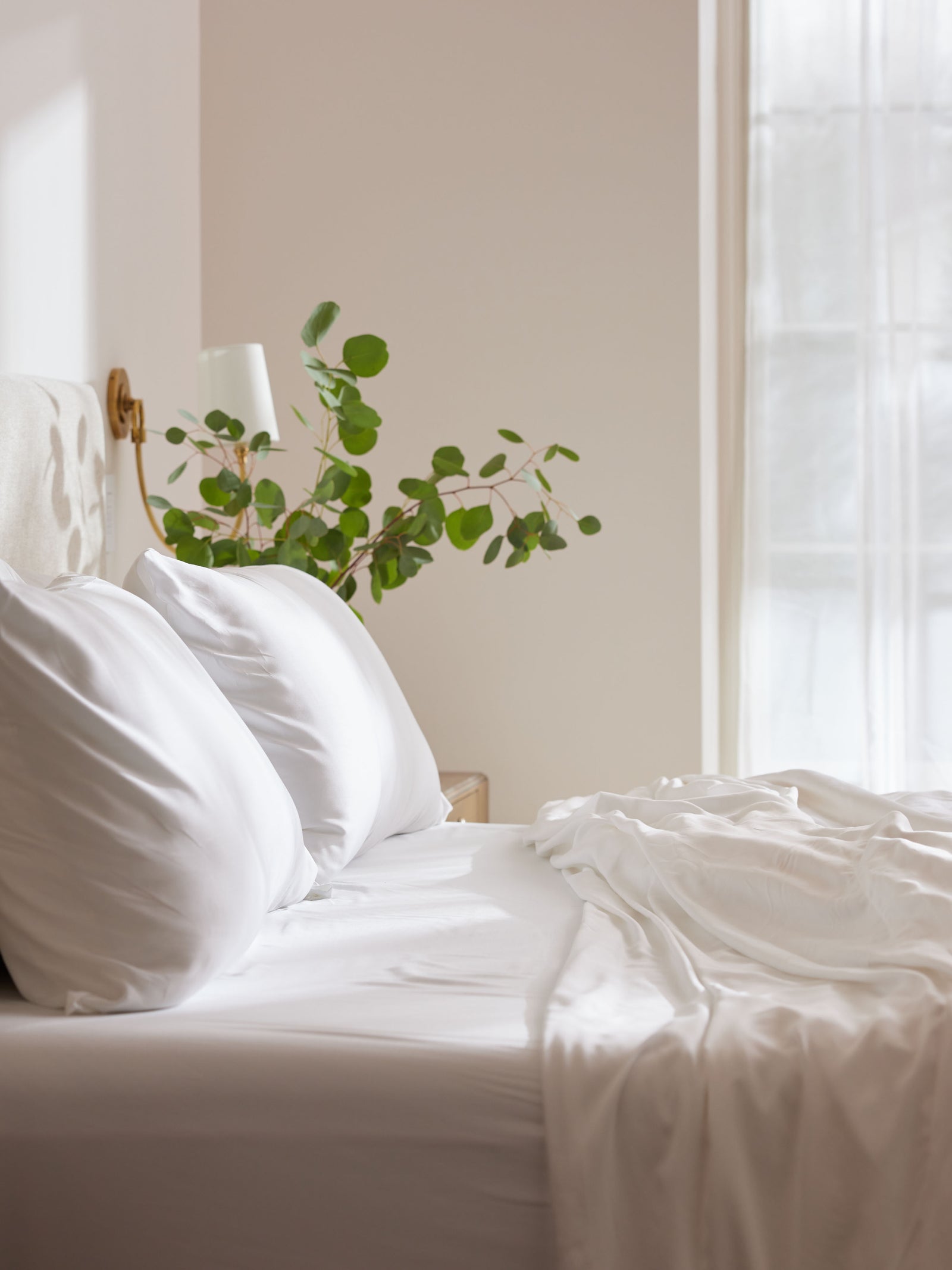 Side view of white bedding on an unmade bed 