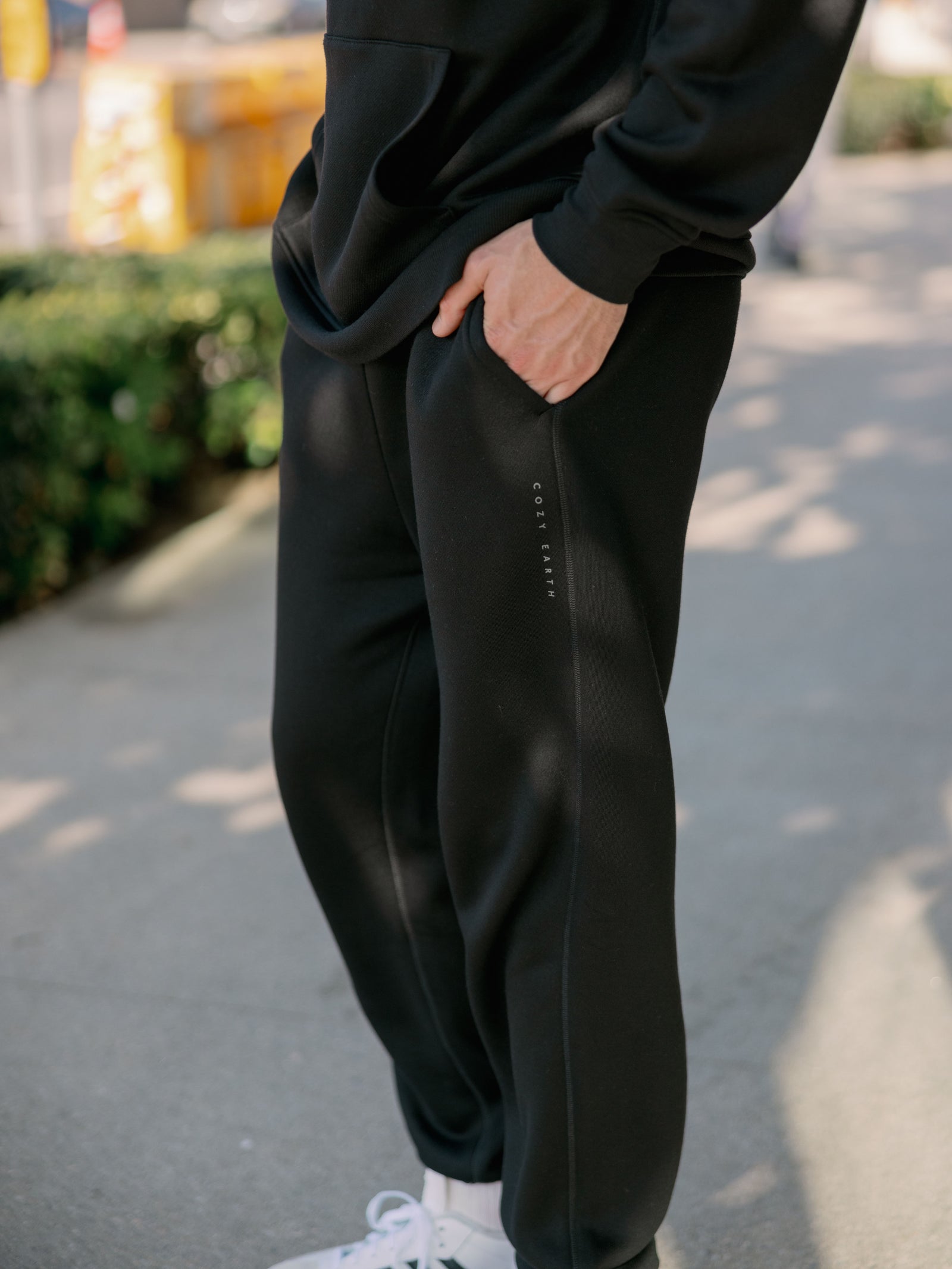 Man wearing black cityscape sweats on sidewalk 