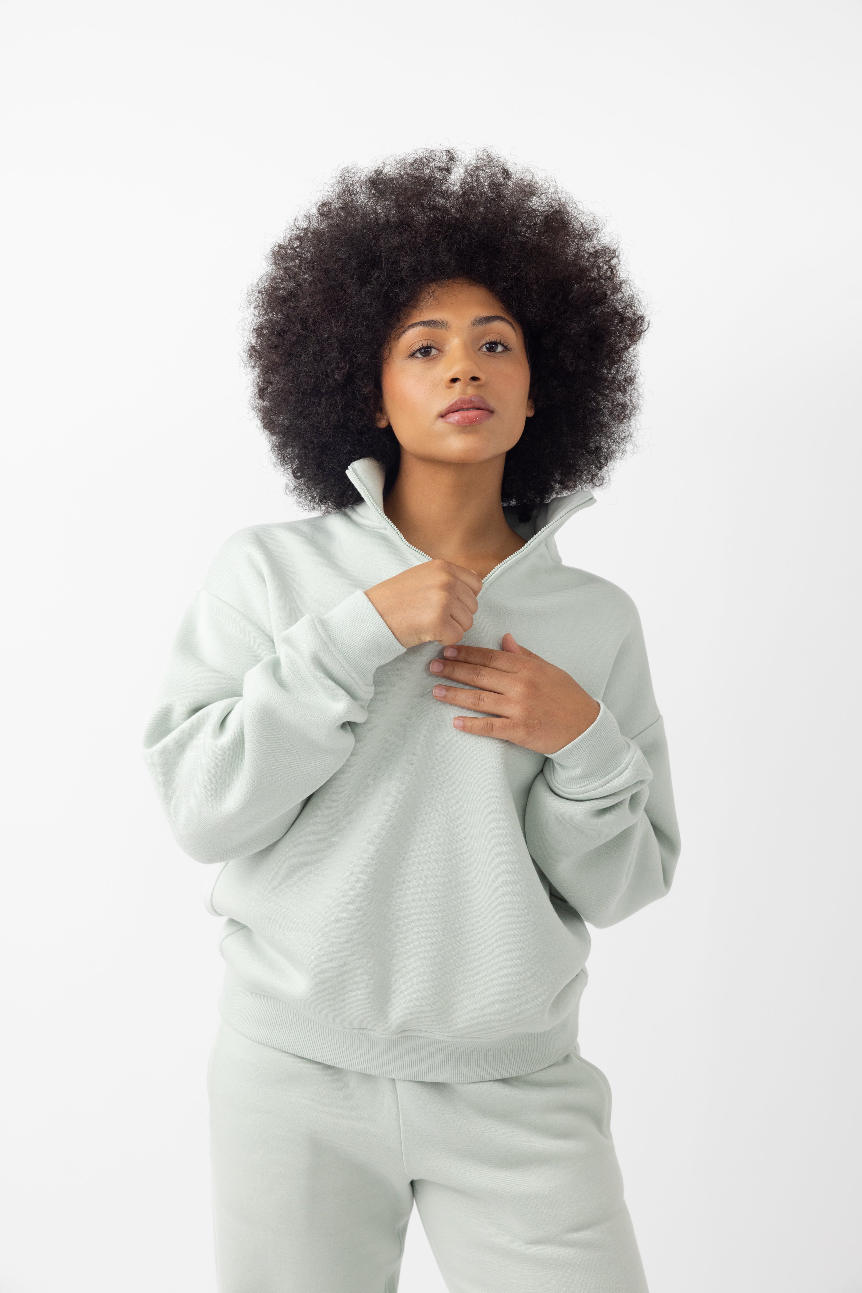 Arctic CityScape Quarter Zip. The quarter zip is being worn by a female model. The model is wearing accompanying CityScape clothing to complete the look of the quarter zip. The photo was taken with a white background. |Color:Arctic