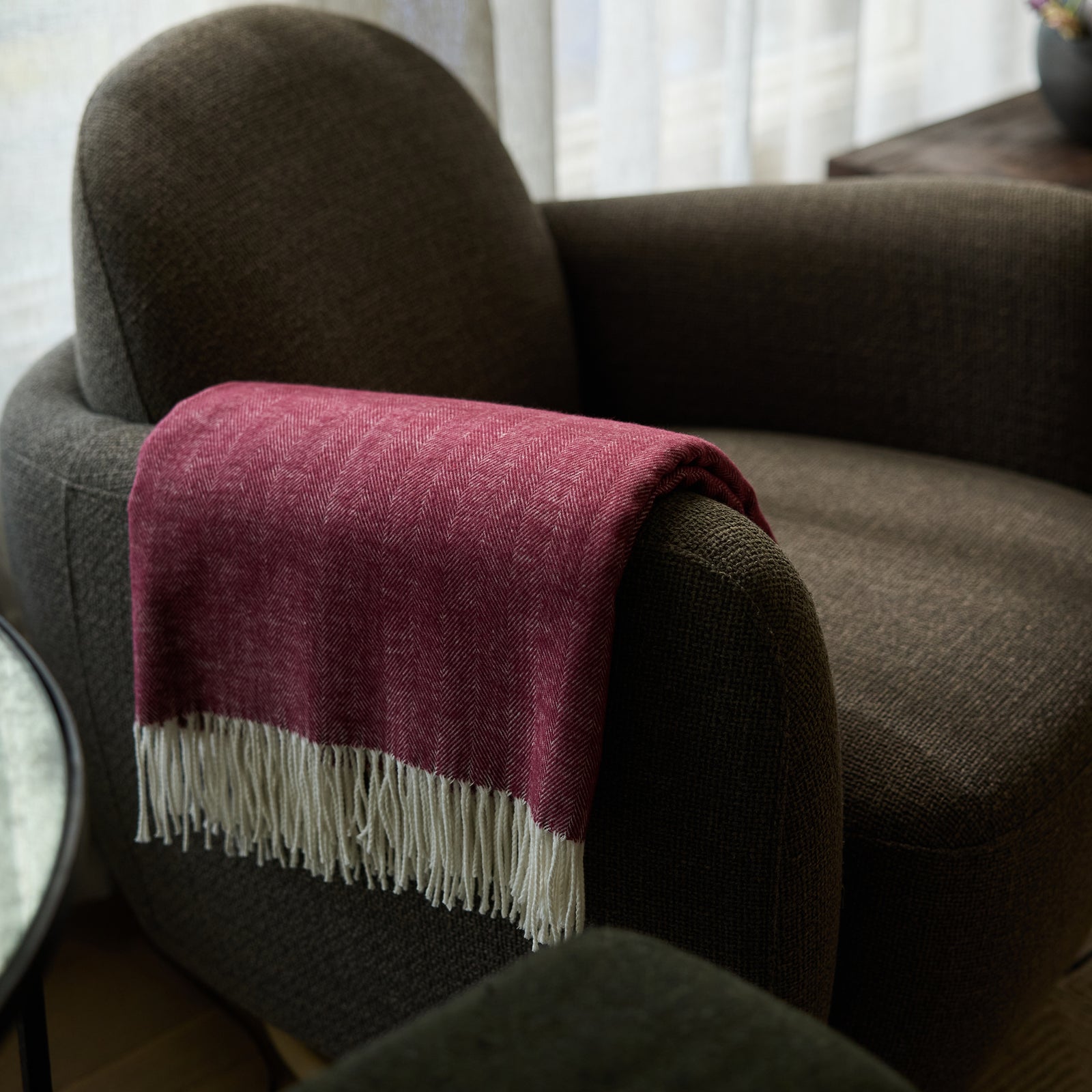 Berry herringbone tassel throw draped over recliner